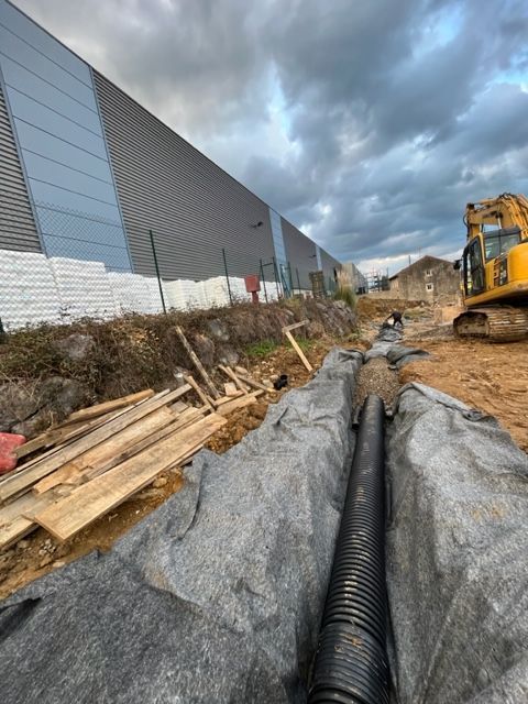 Un sitio de construcción con una excavadora amarilla al fondo