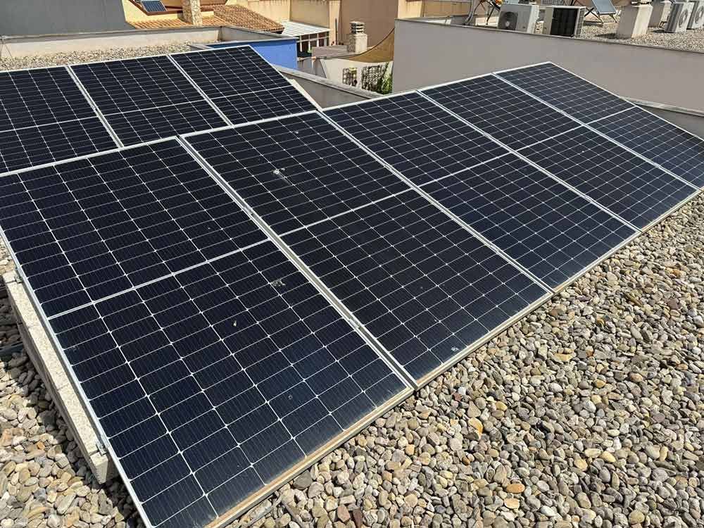 Paneles solares en un techo de grava, capturando la luz solar.