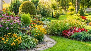 Jardin fleuri aux couleurs vives, avec un sentier de pierre serpentant entre des parterres en fleurs et des arbustes verdoyants