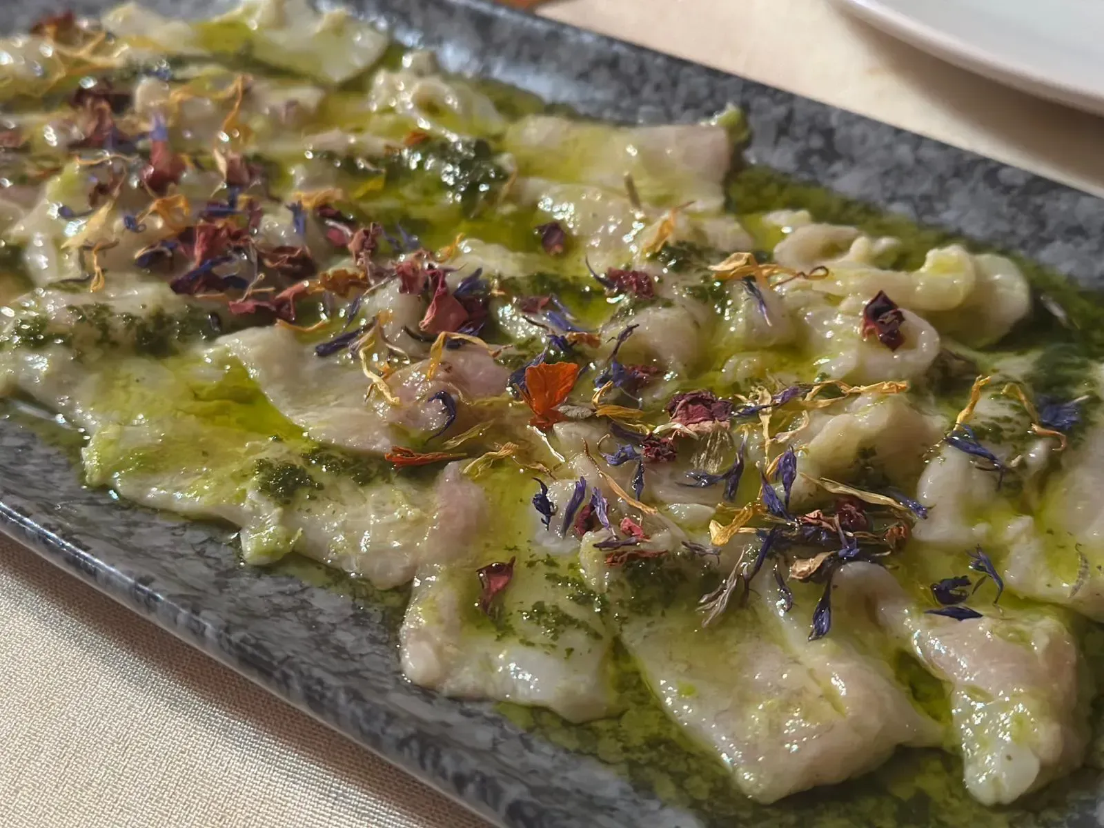 Guantes rosas, esponjas y una botella de spray sobre un fondo rosa.