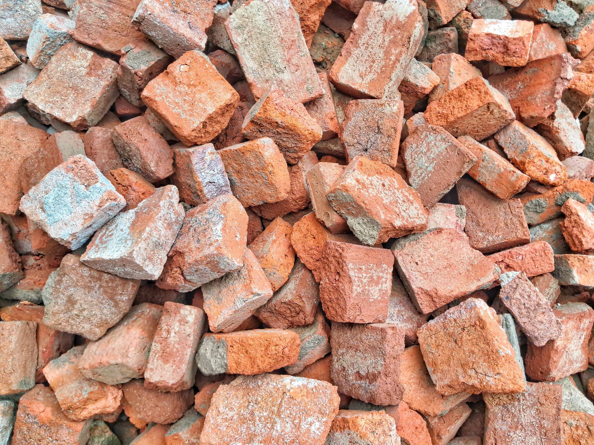 Gros plan sur un tas de fragments de briques cassées, de formes et de tailles variées.