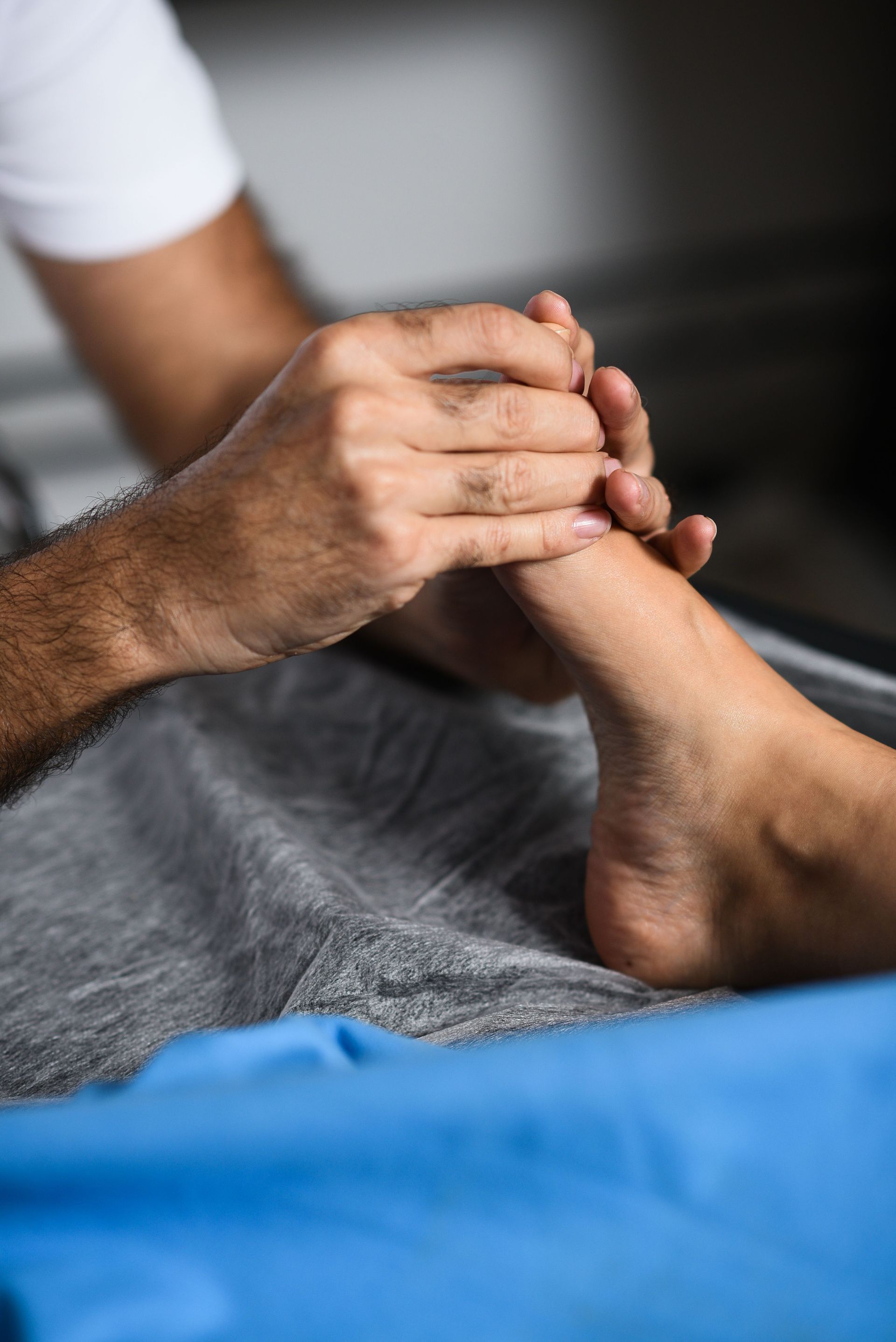 Un hombre le está dando un masaje de pies a una mujer.