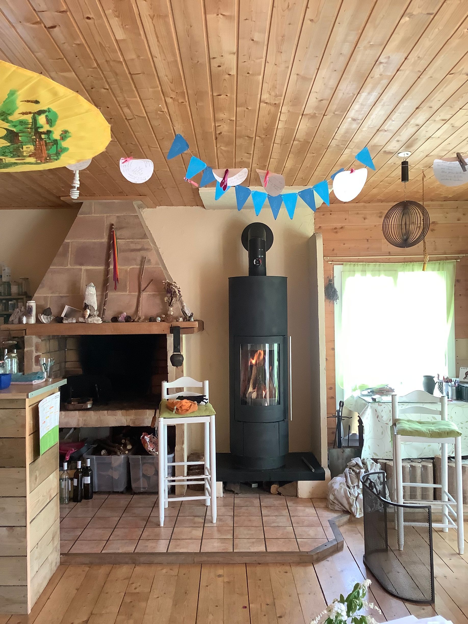 Une pièce rustique avec une cheminée en pierre, un poêle à bois noir.