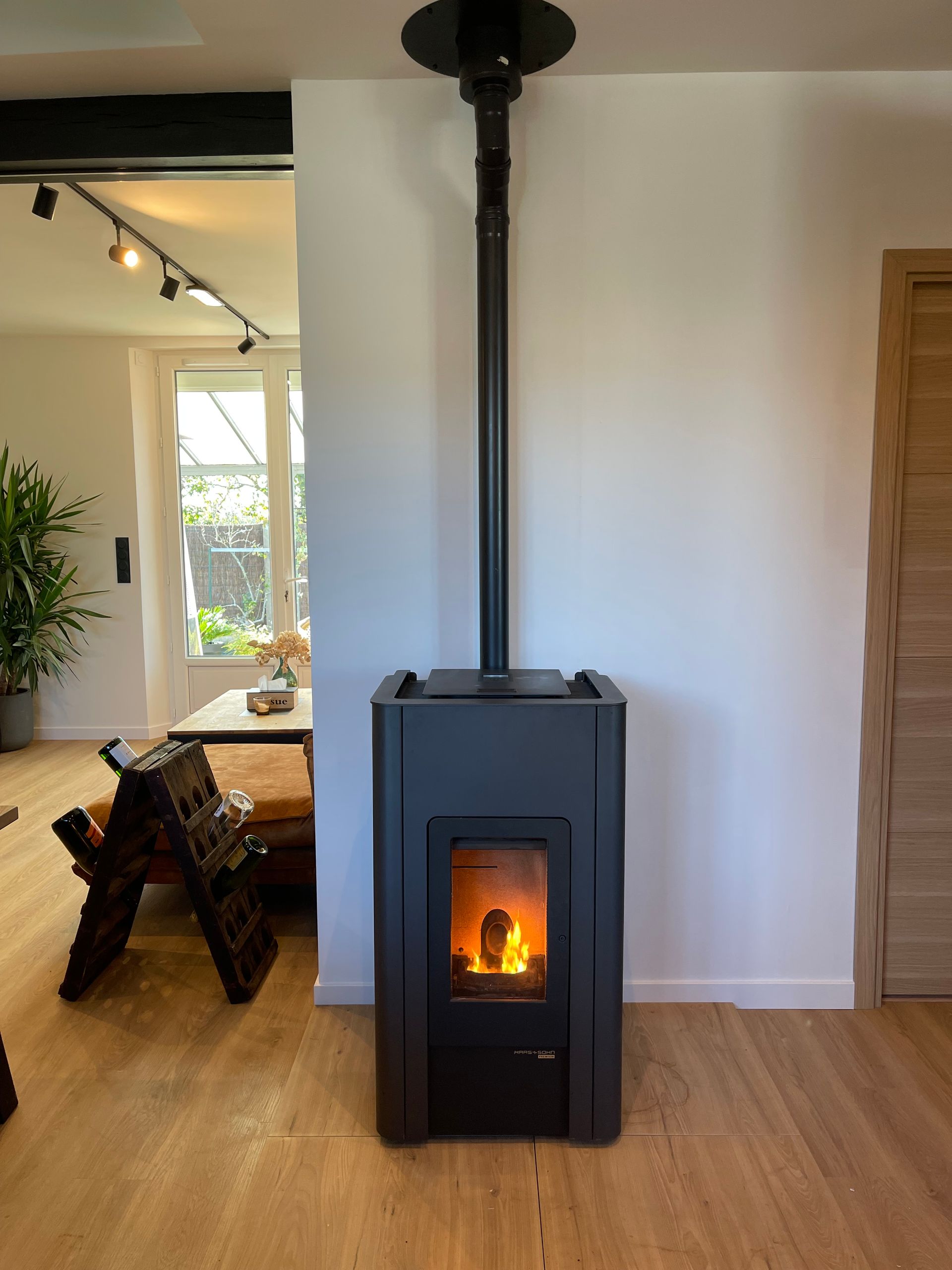 Un poêle à granulés noirs brûle, sa flamme étant visible.