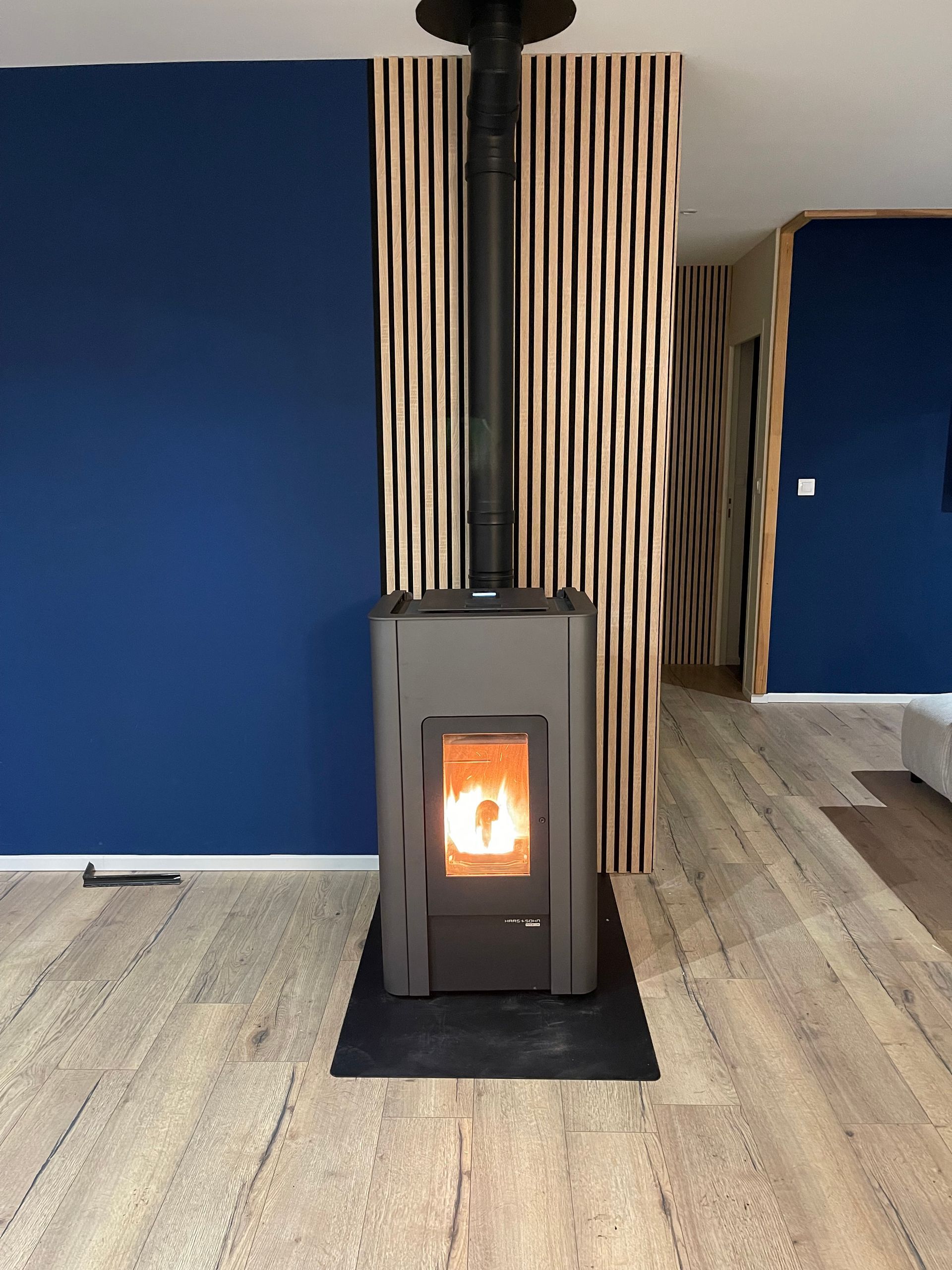 Dans une maison moderne, un poêle à granulés allumé.