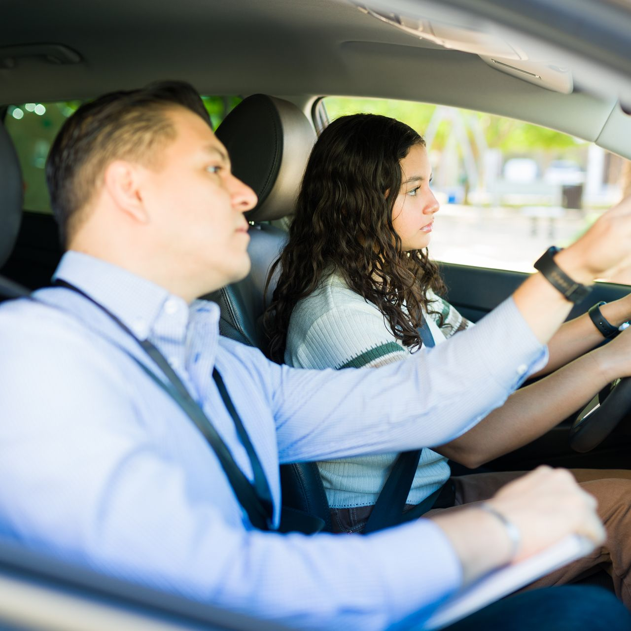 Jeune conductrice avec un moniteur en voiture