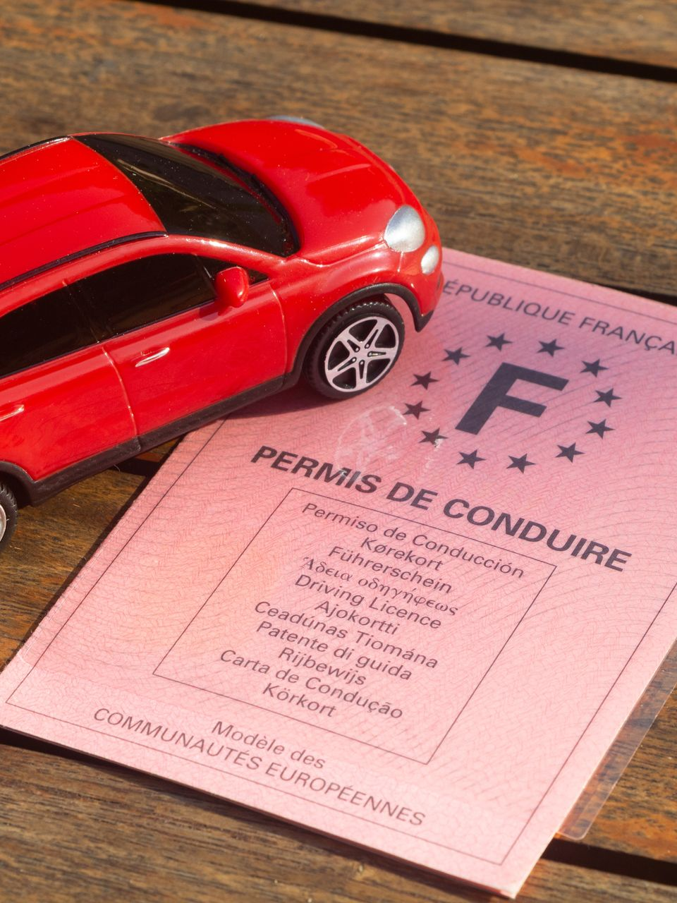 Document du permis de conduire avec une voiture miniature rouge