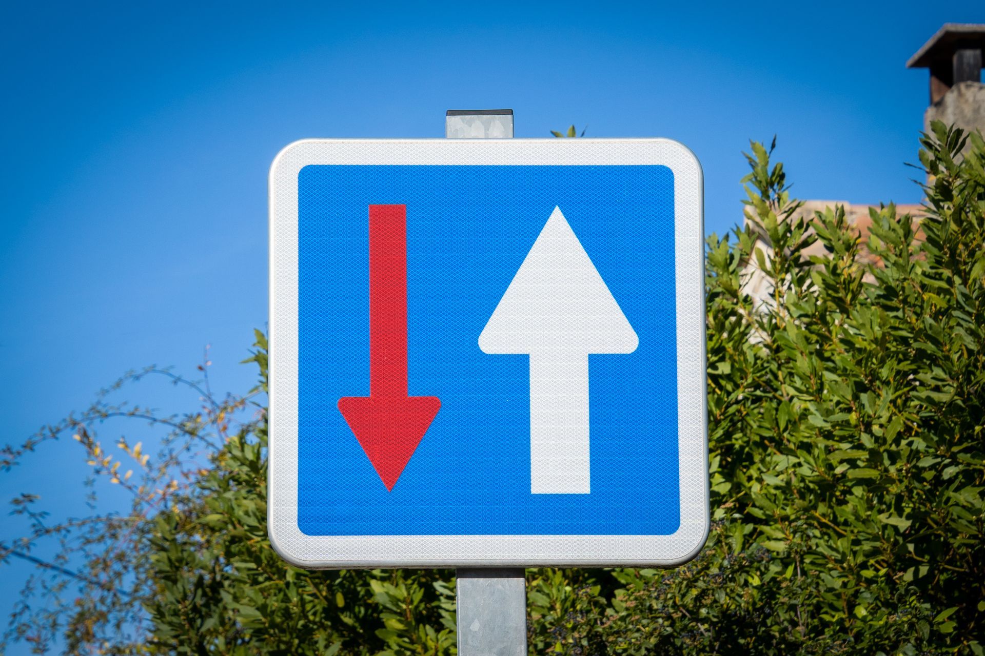 Panneau routier bleu avec une flèche blanche