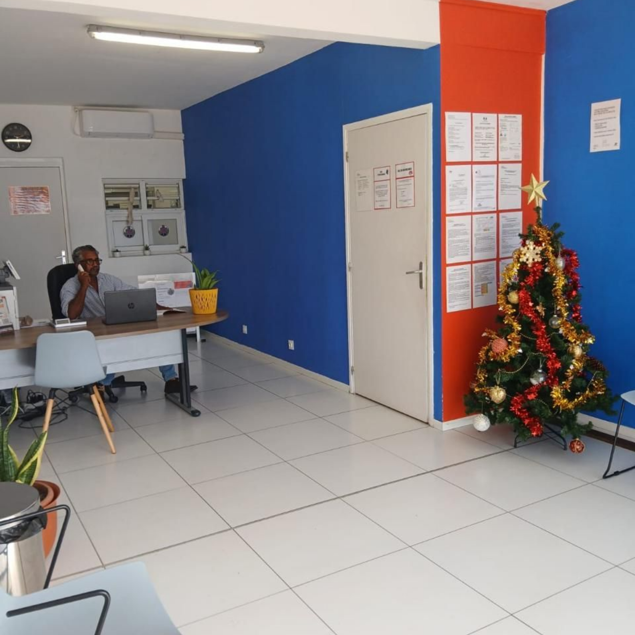 M. Virapin assis au comptoir d'accueil de l'auto-école