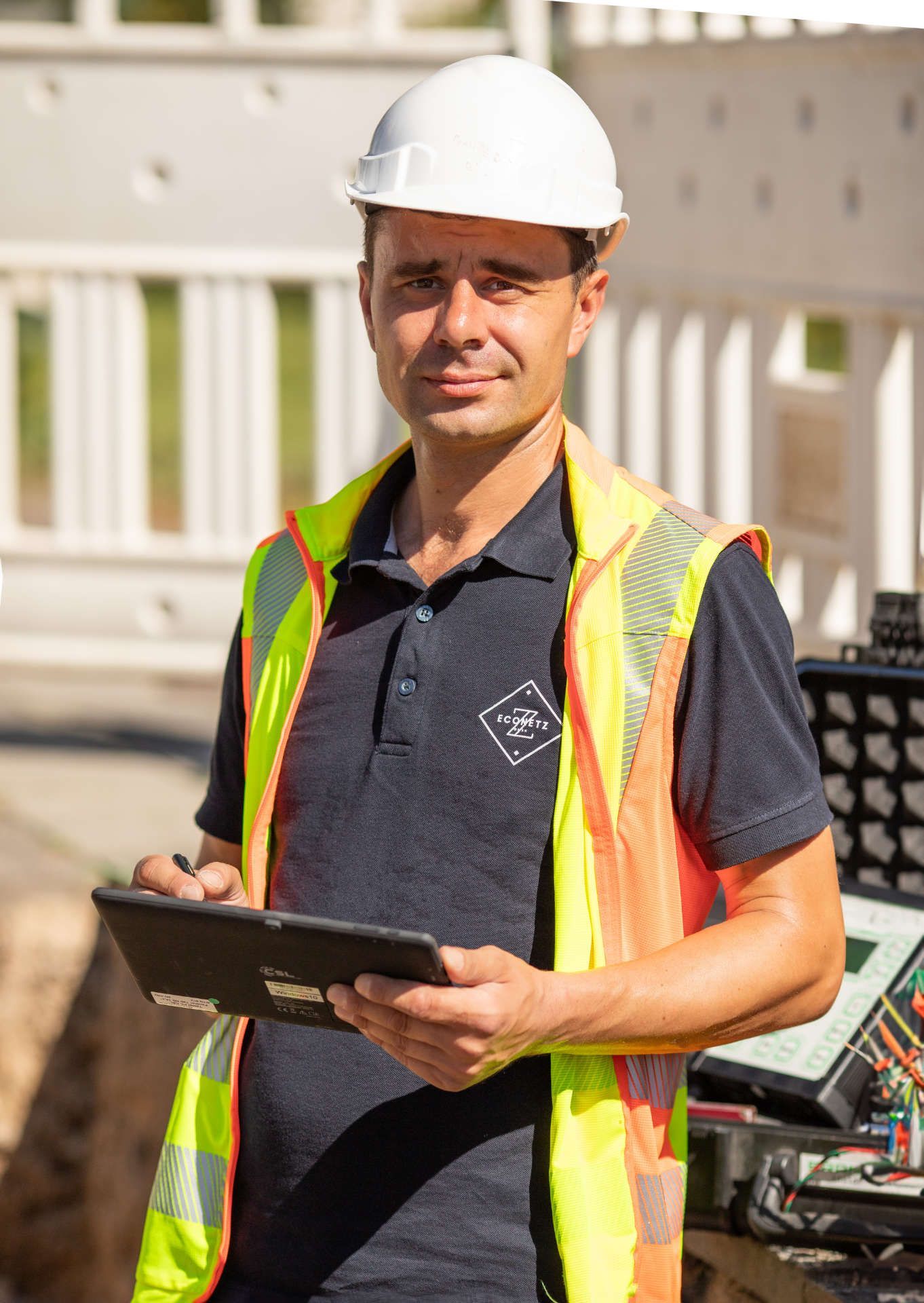 Bauleiter ist auf einer Baustelle und überwacht alle mit einem Tablet in der Hand