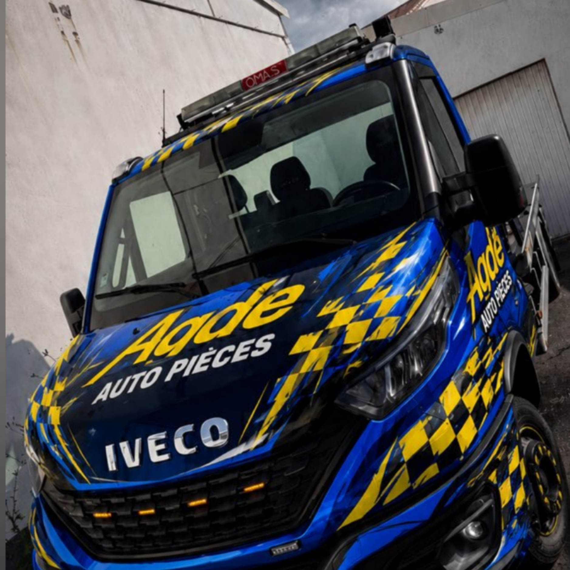 Camion de dépannage Iveco bleu et jaune, appartenant à l'entreprise Agde Auto Pièces.
