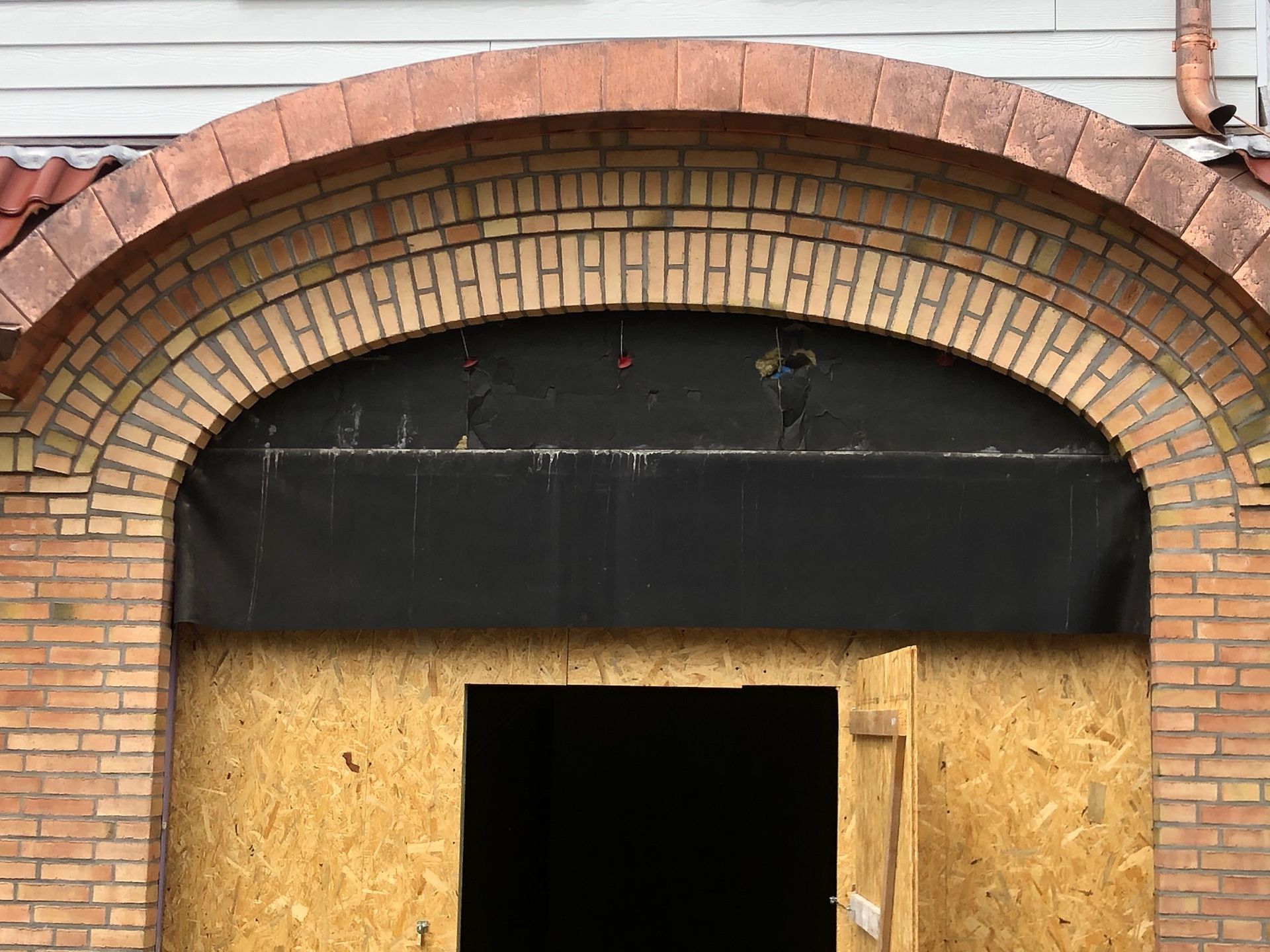 Ein gemauerter Torbogen mit einer Tür in der Mitte