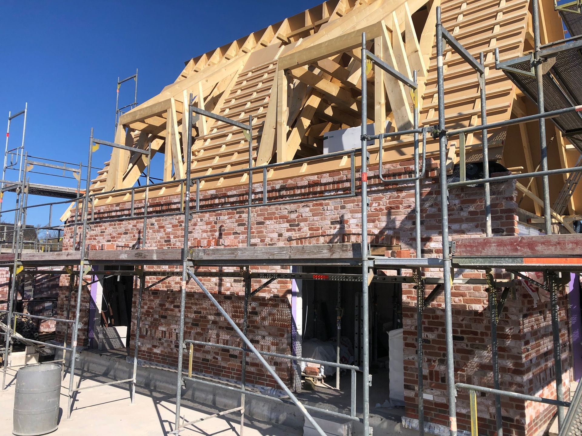 Es wird ein Backsteingebäude errichtet, das von einem Gerüst umgeben ist.