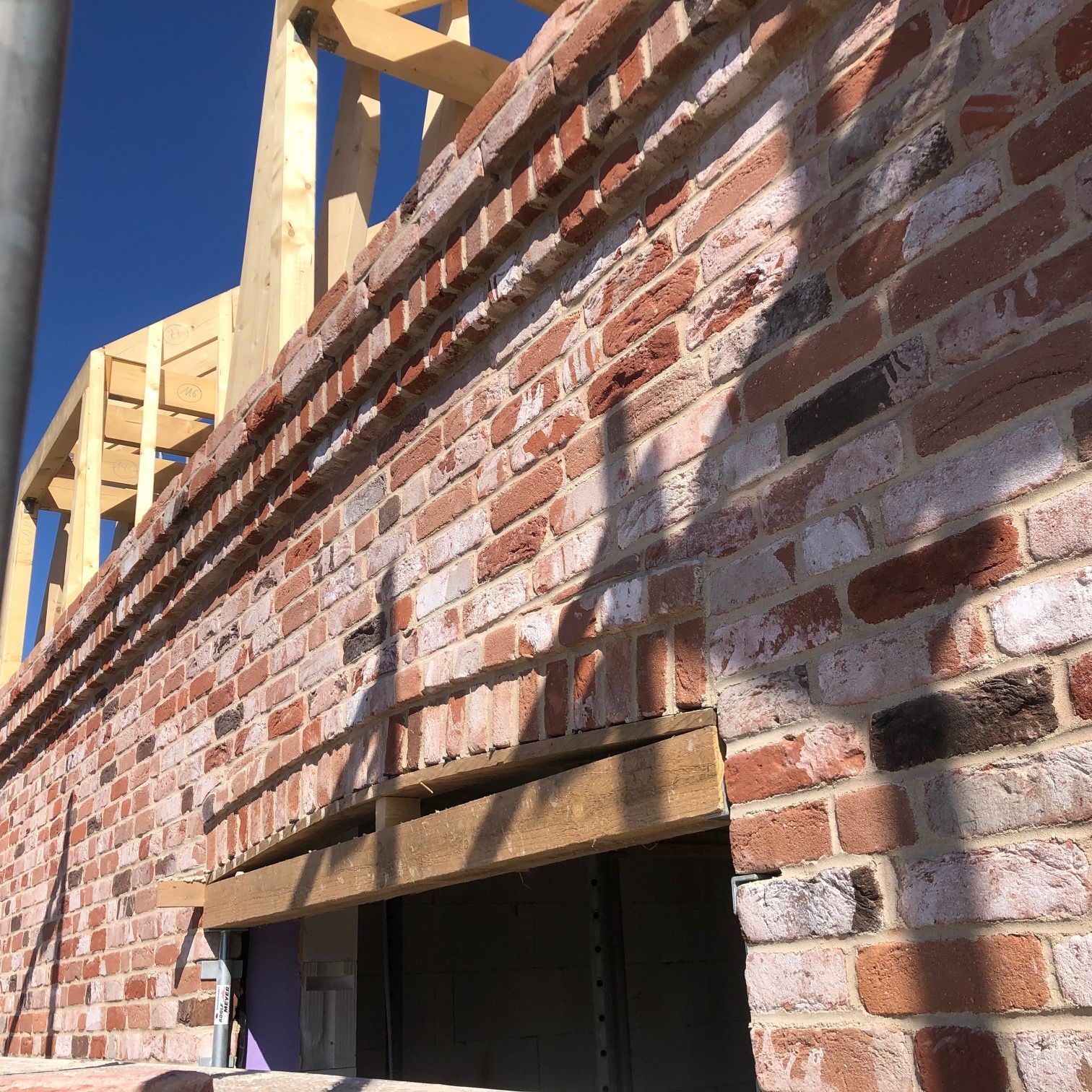 Eine Ziegelwand mit einem Holzrahmen dahinter