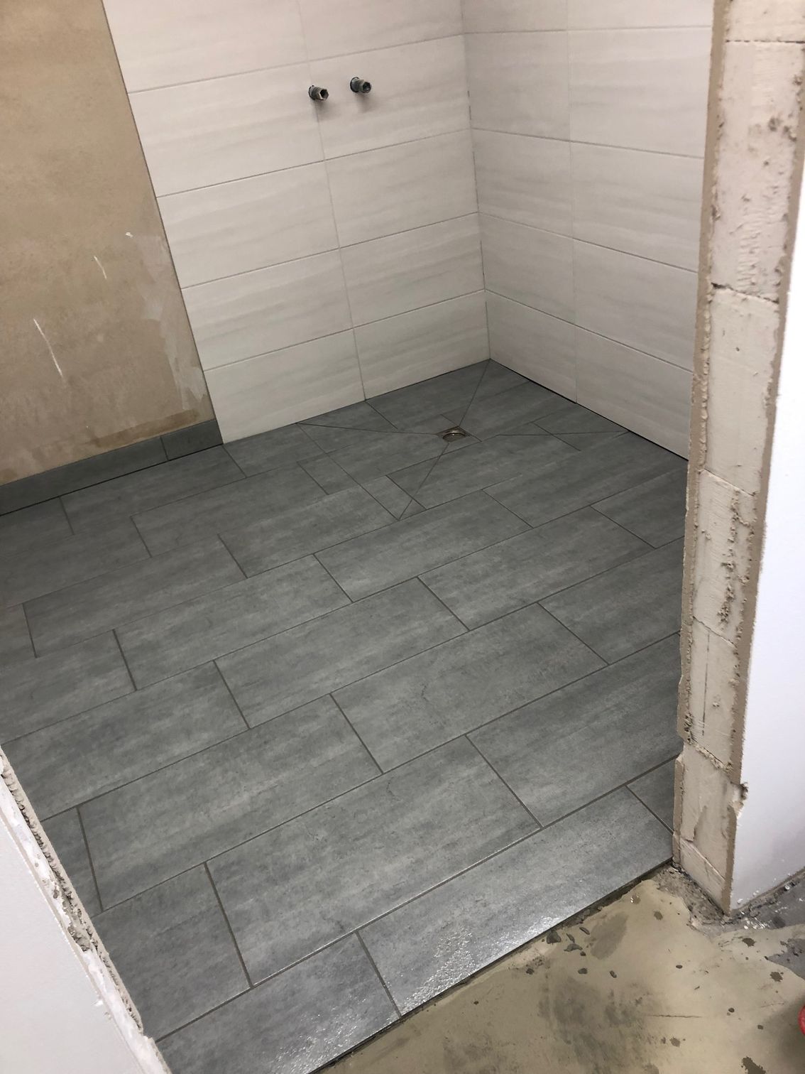 Ein Badezimmer mit gefliestem Boden und weißen Wänden.