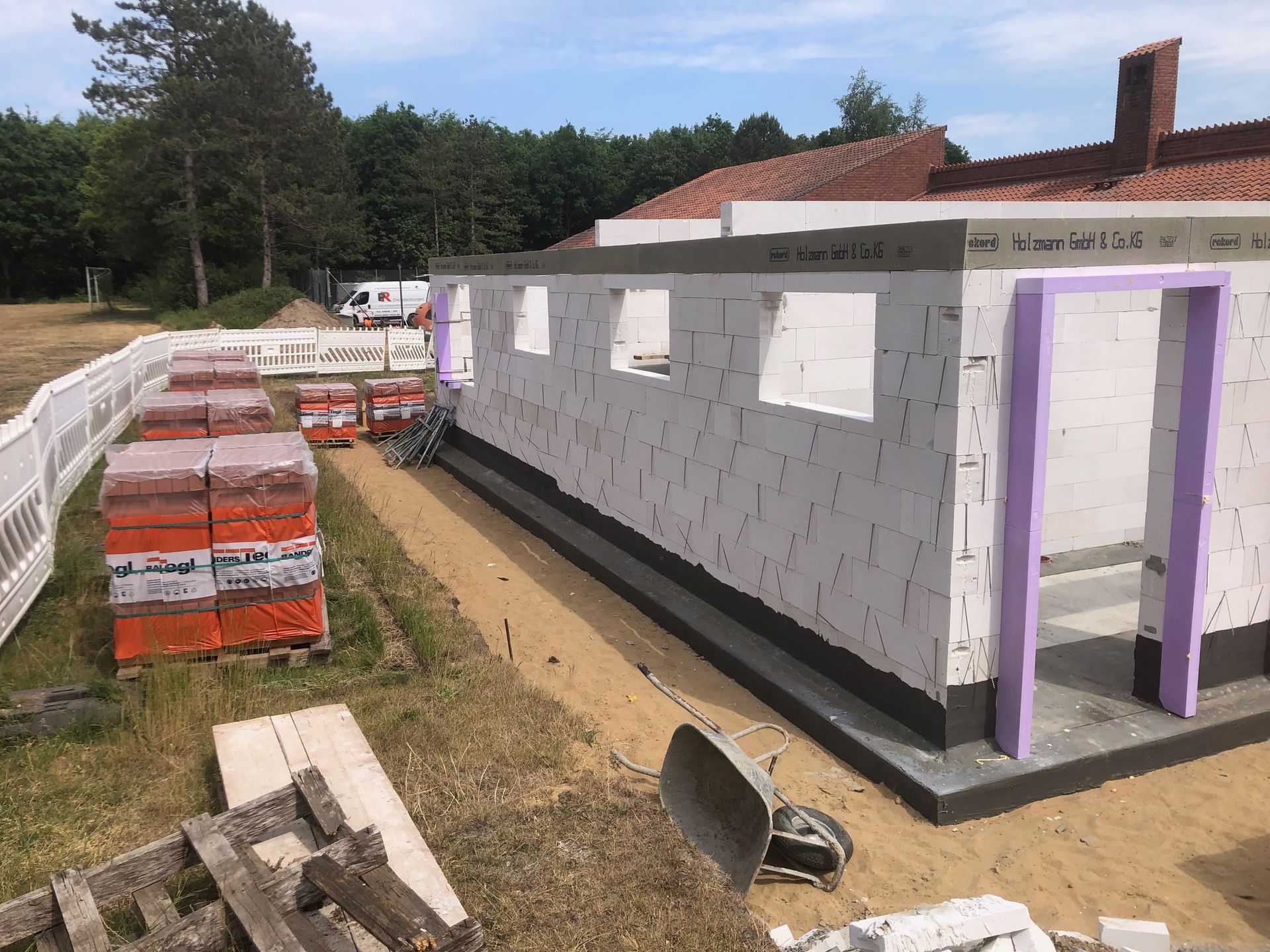 Ein Gebäude wird aus Ziegeln und violetten Verzierungen gebaut