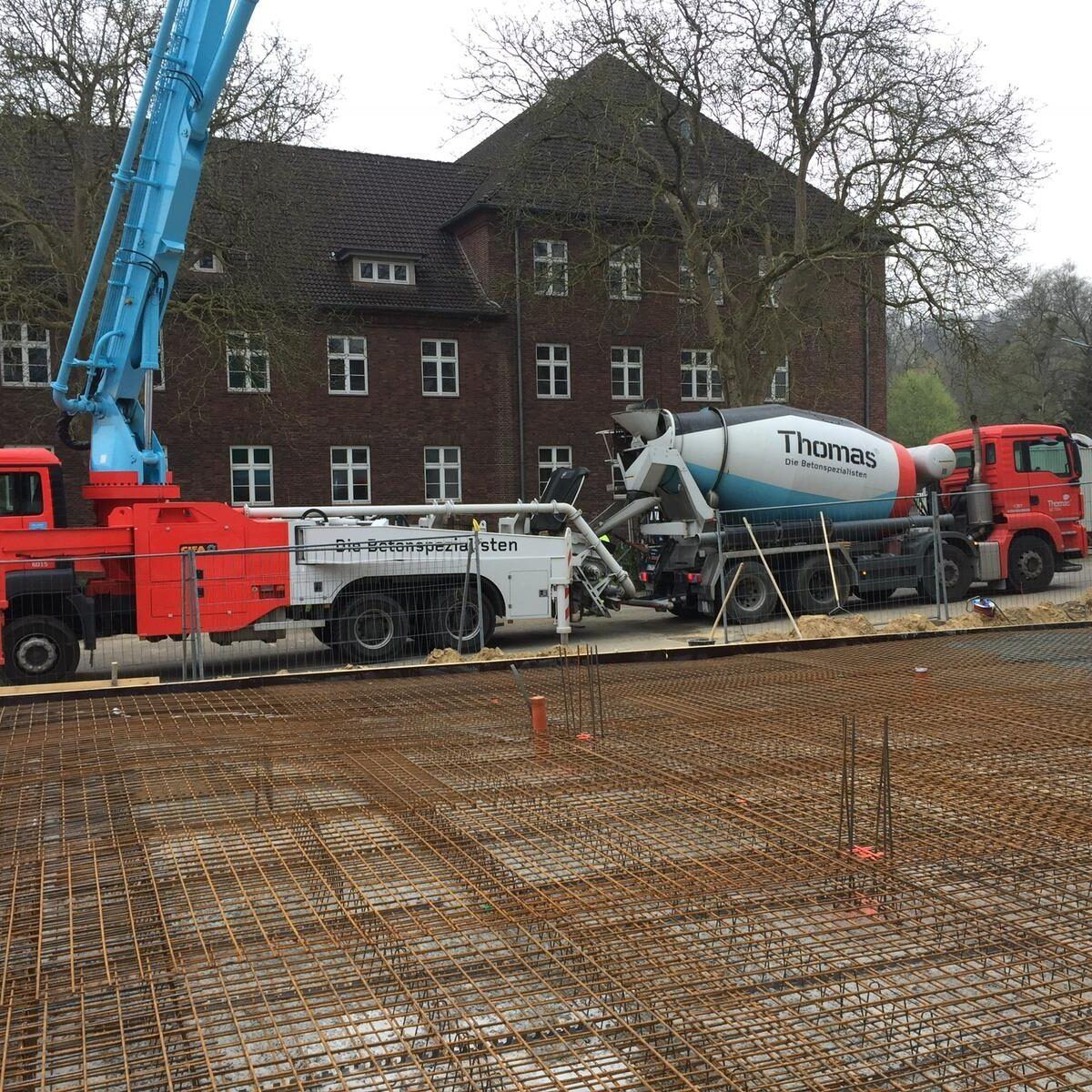Ein Betonmischer von Thomas gießt Beton auf einer Baustelle