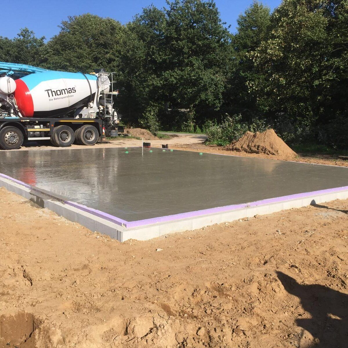 Ein Betonmischer gießt Beton in eine Betonplatte