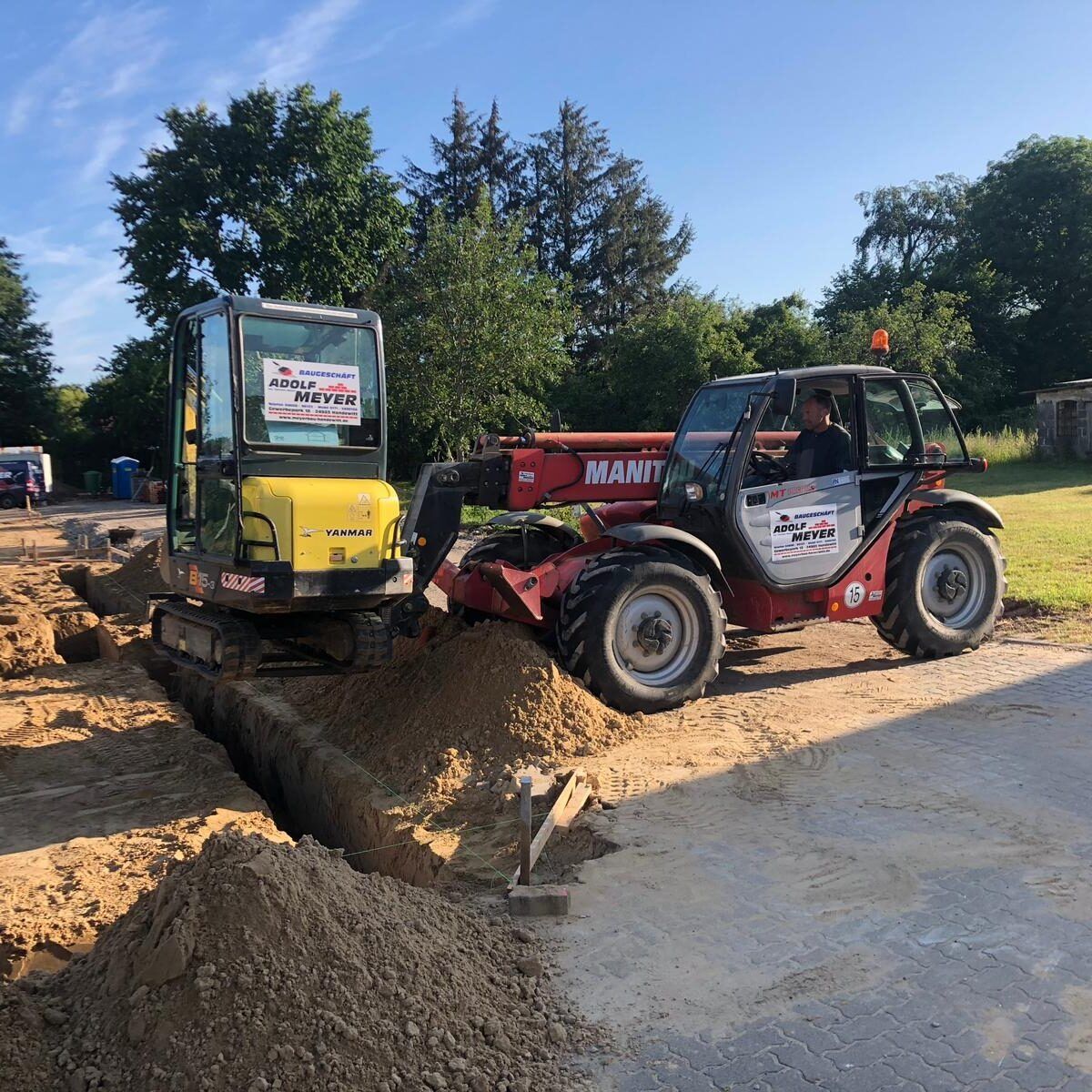 Ein Mann fährt einen Gabelstapler auf einer unbefestigten Straße