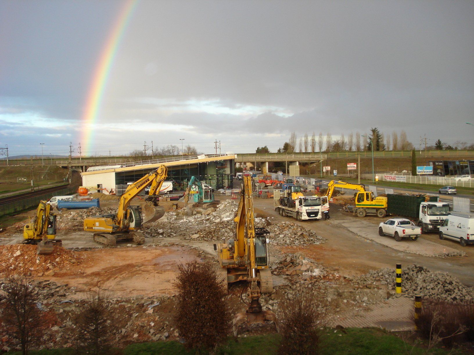 Travaux de démolition devant un arc-en-ciel