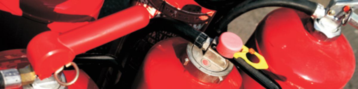 Ein Haufen roter Feuerlöscher ist übereinander gestapelt.