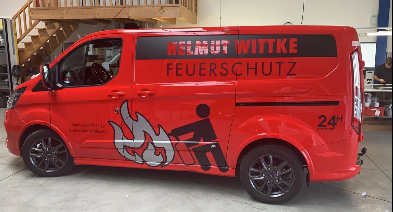 Ein roter Lieferwagen mit Helmut Witke Feuerschutz auf der Seite geschrieben
