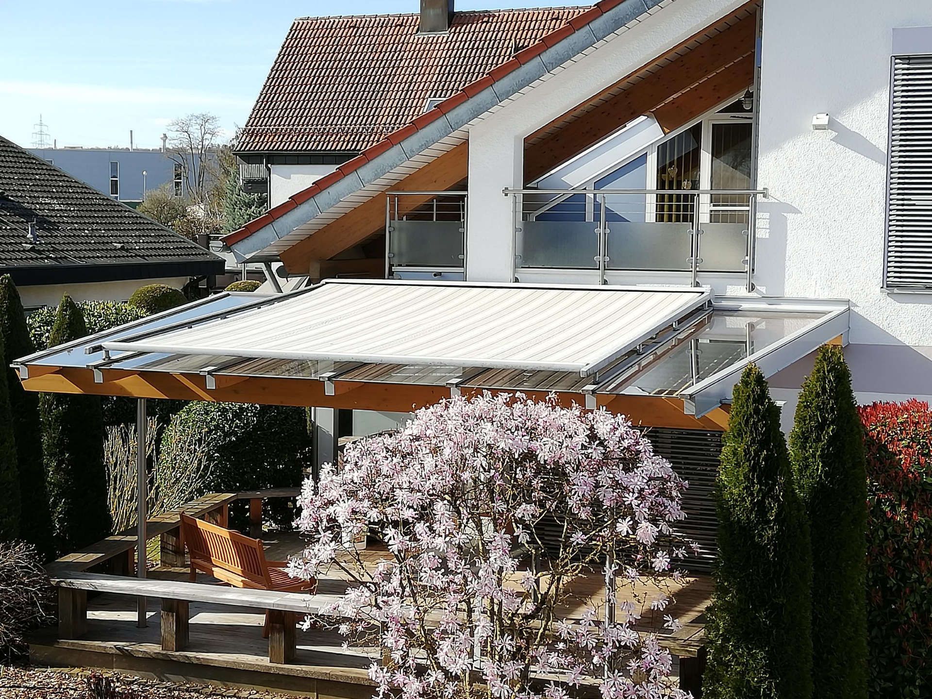 Markise einer Terrasse mit Glasüberdachung und angrenzendem Balkon