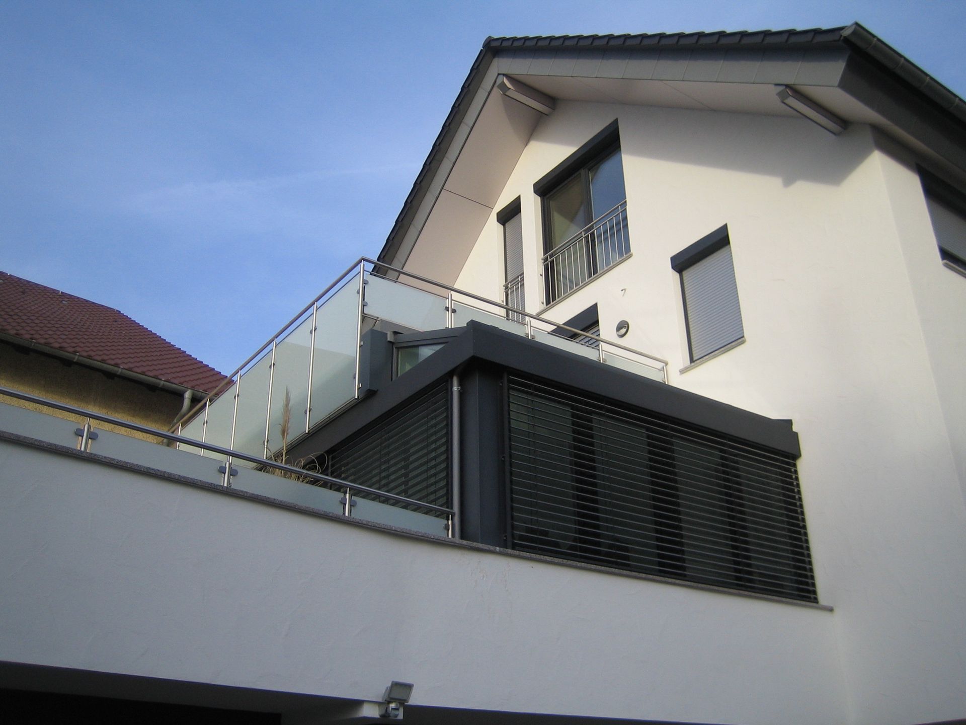 Eine gläsender Zaun auf einer Terrasse