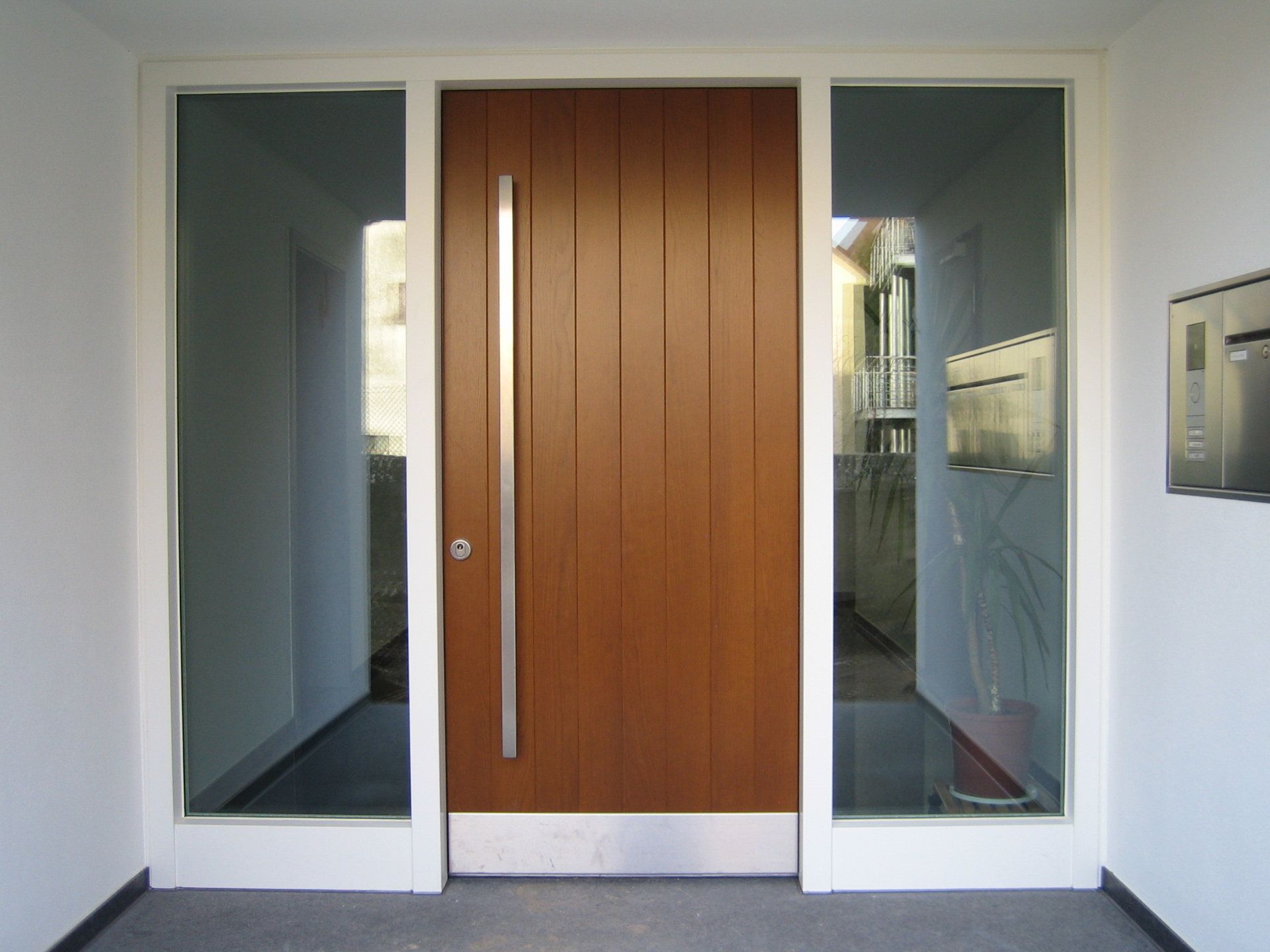 Eine moderne Vollholztür zwischen zwei Glasscheiben