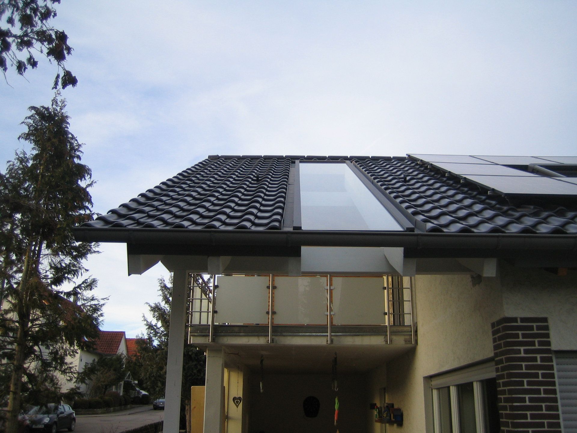 Eine Glasscheibe längs auf einem Dach über einer Terrasse eingebaut