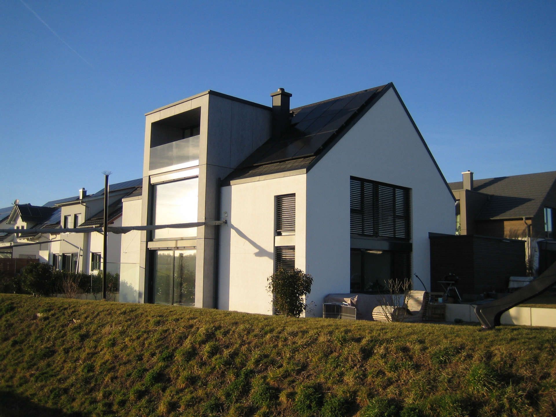Große Fenster, Glastüren und Glasüberdachung eines modernen Neubauhauses