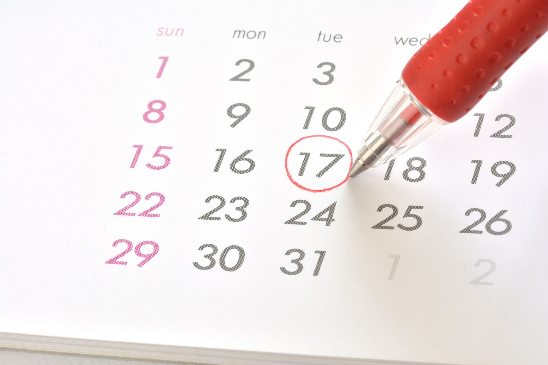 Un calendrier avec le 17 entouré en rouge, un stylo rouge pointé dessus.