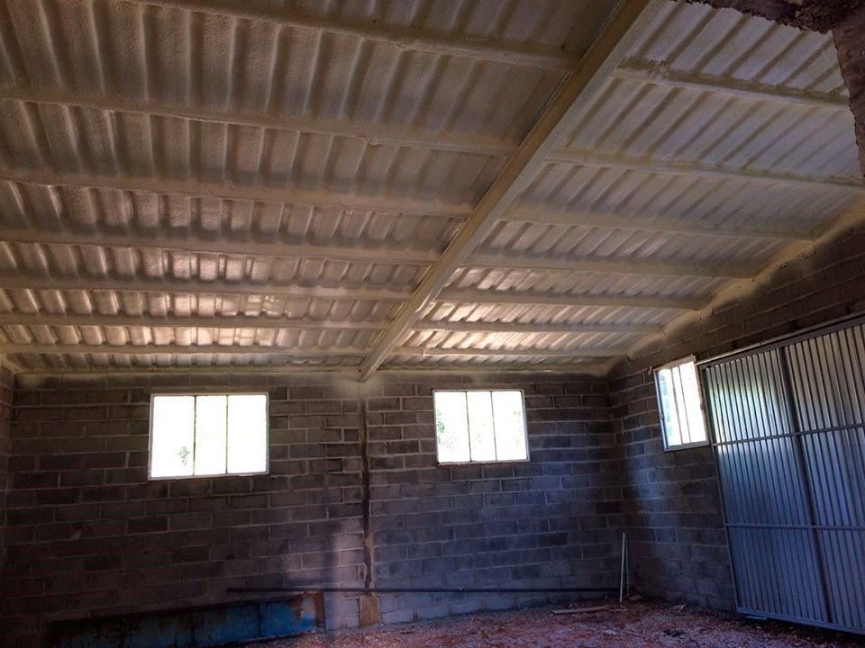 Un edificio de ladrillo con techo y ventanas de metal