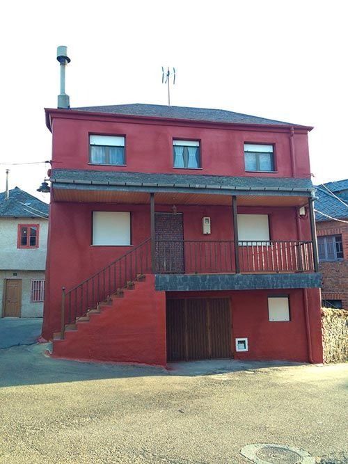 Una casa roja con escaleras que conducen al segundo piso.
