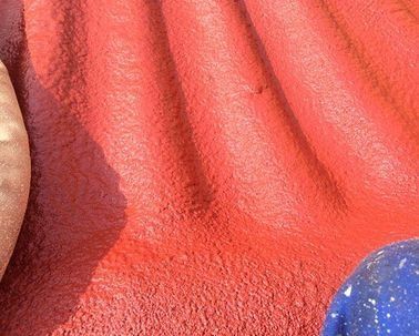 Un primer plano de una pared roja con una bola azul en primer plano.