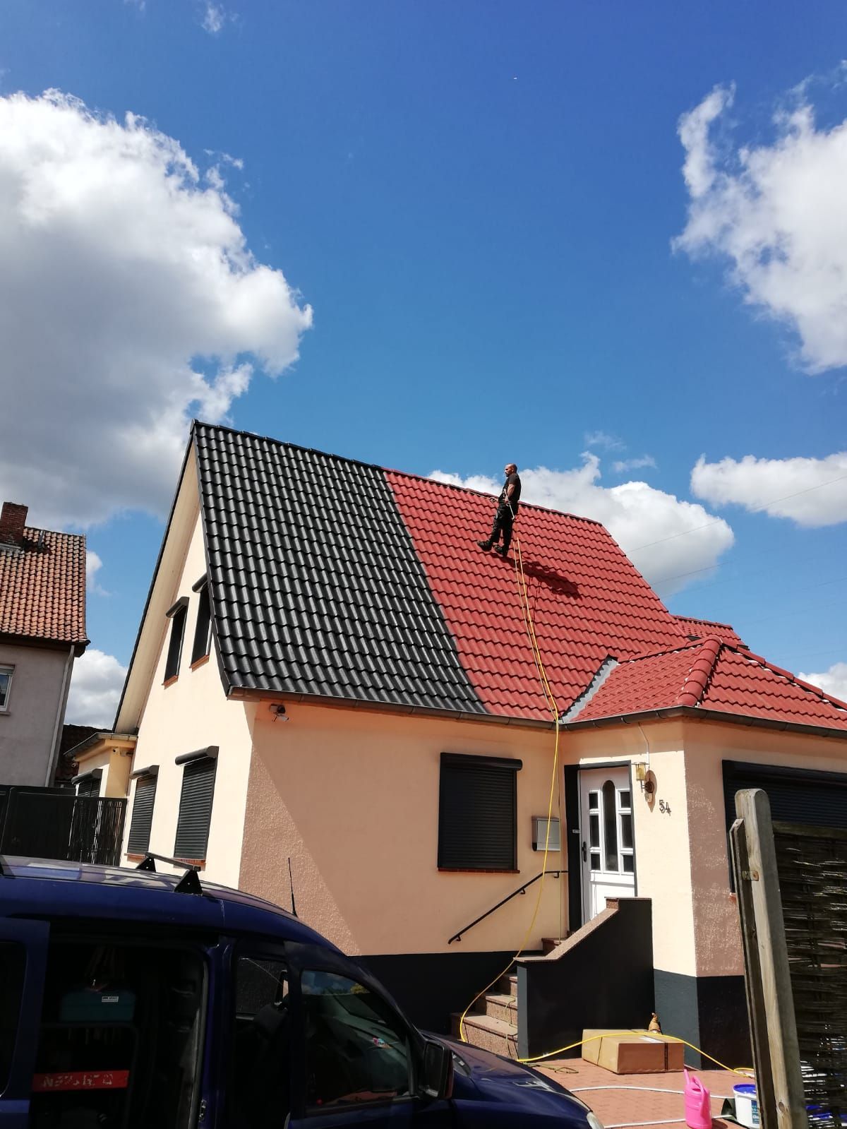 Ein Mann steht auf dem Dach eines Hauses.