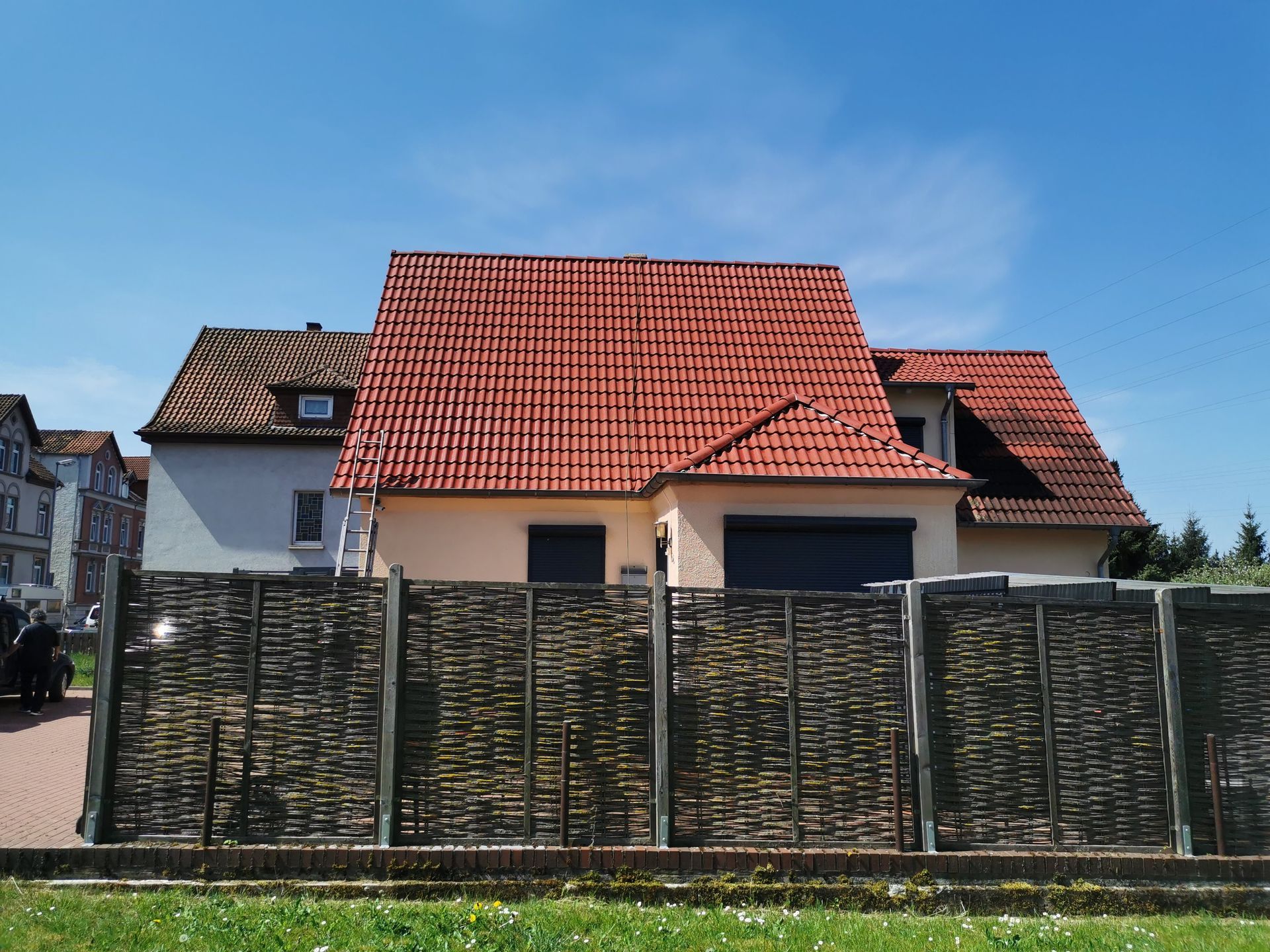 Ein Haus mit einem roten Dach und einem Zaun davor