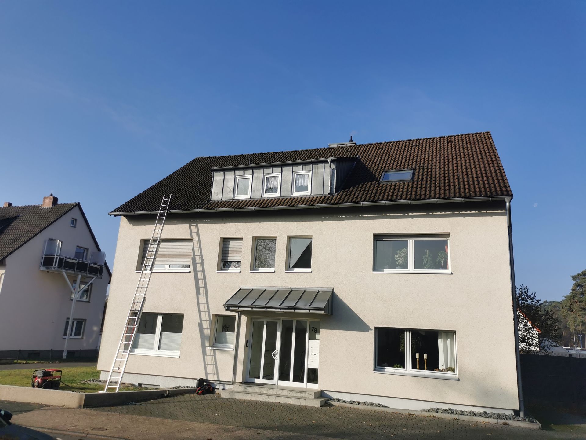 Ein weißes Haus mit einer Leiter an der Seite