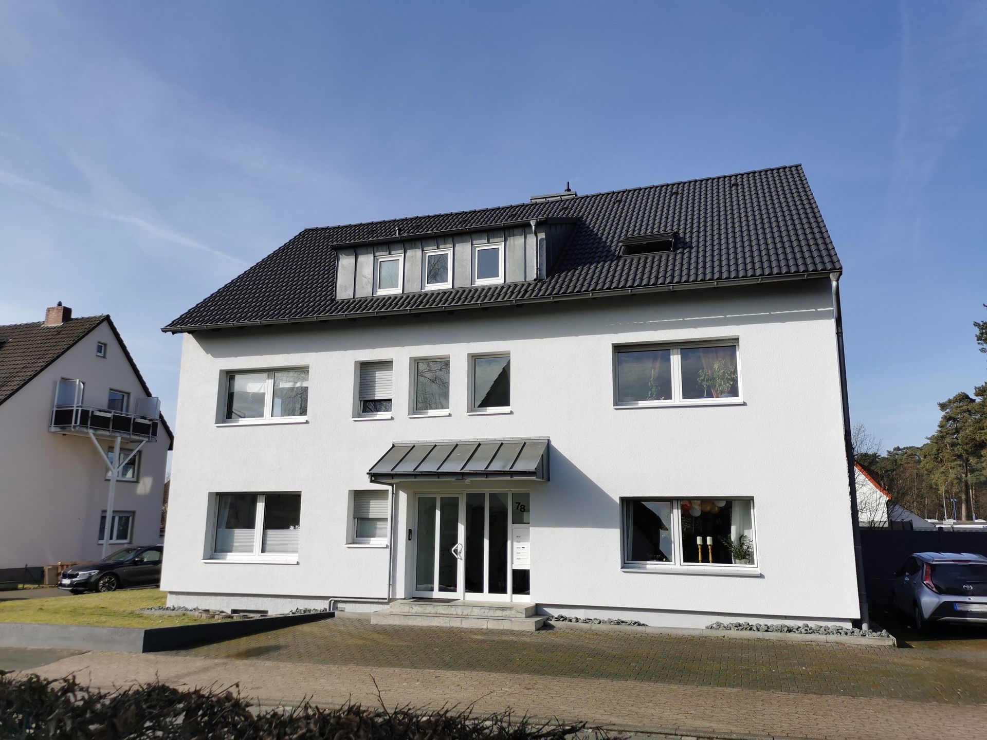 Ein großes weißes Haus mit einem schwarzen Dach