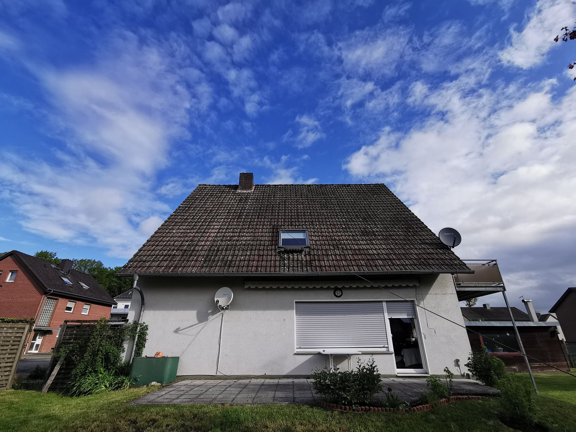 Ein kleines weißes Haus mit einer Satellitenschüssel auf dem Dach