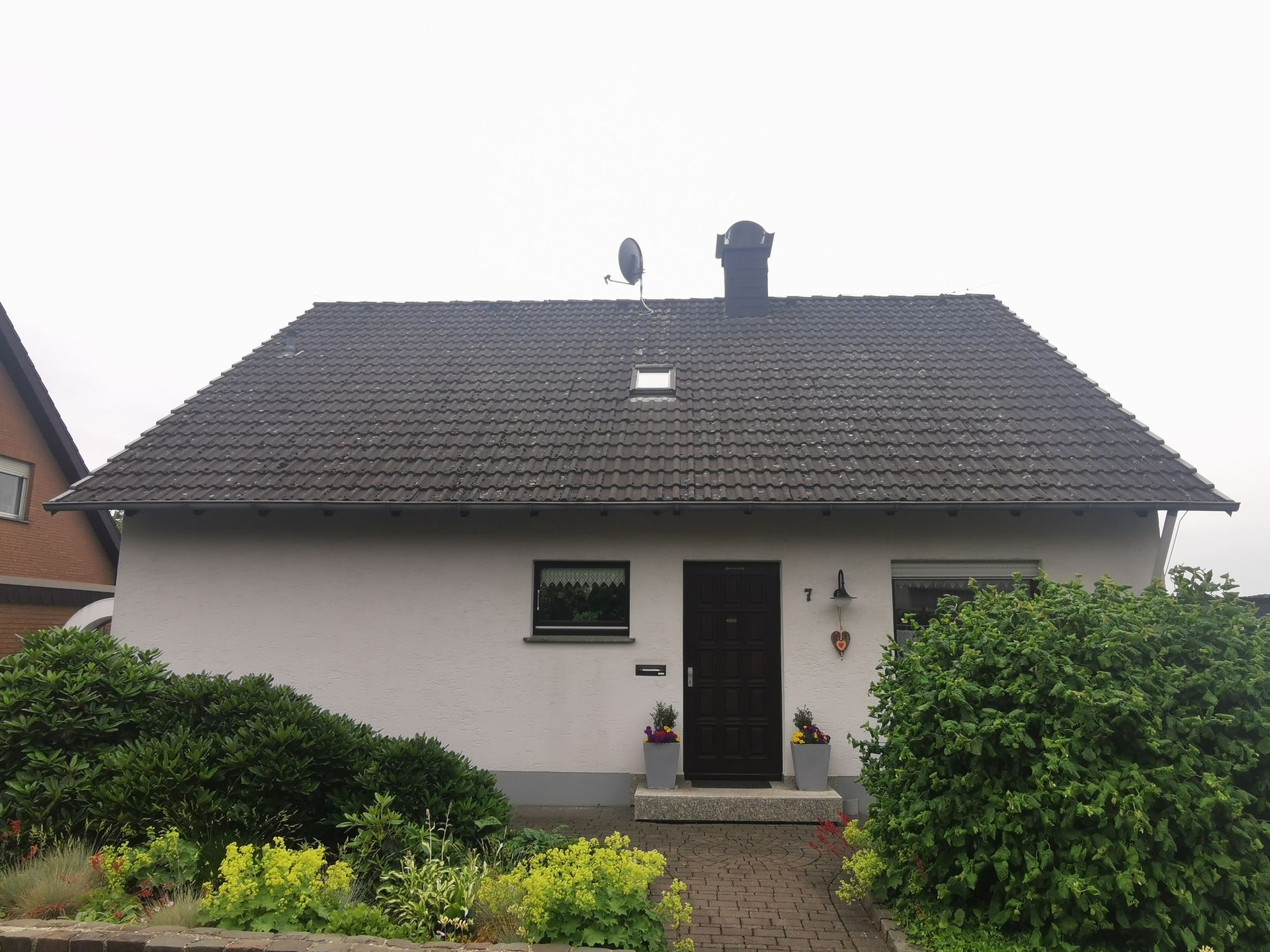 Ein weißes Haus mit einer schwarzen Tür und einem schwarzen Dach