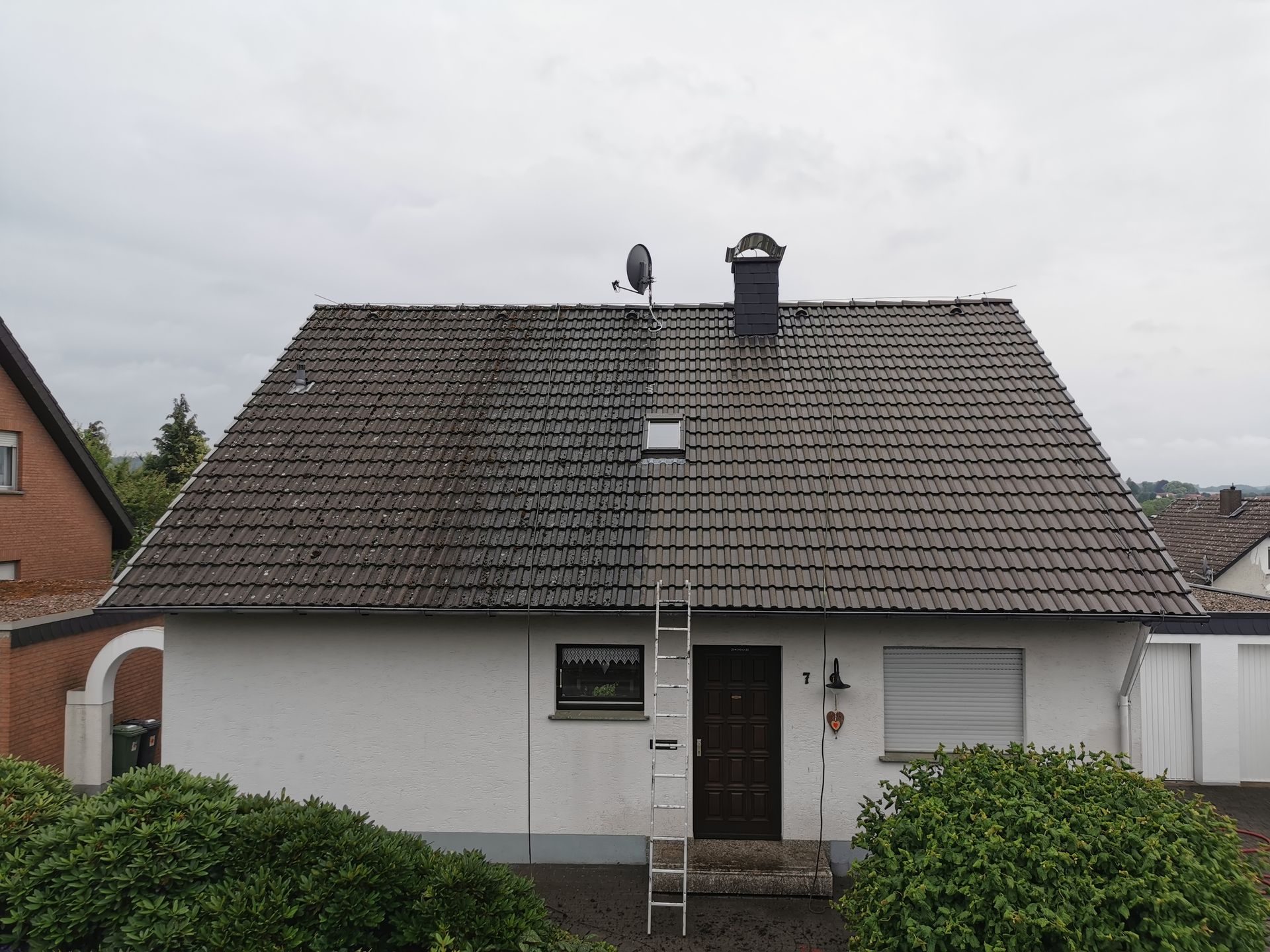 Auf dem Dach eines Hauses ist eine Leiter befestigt.