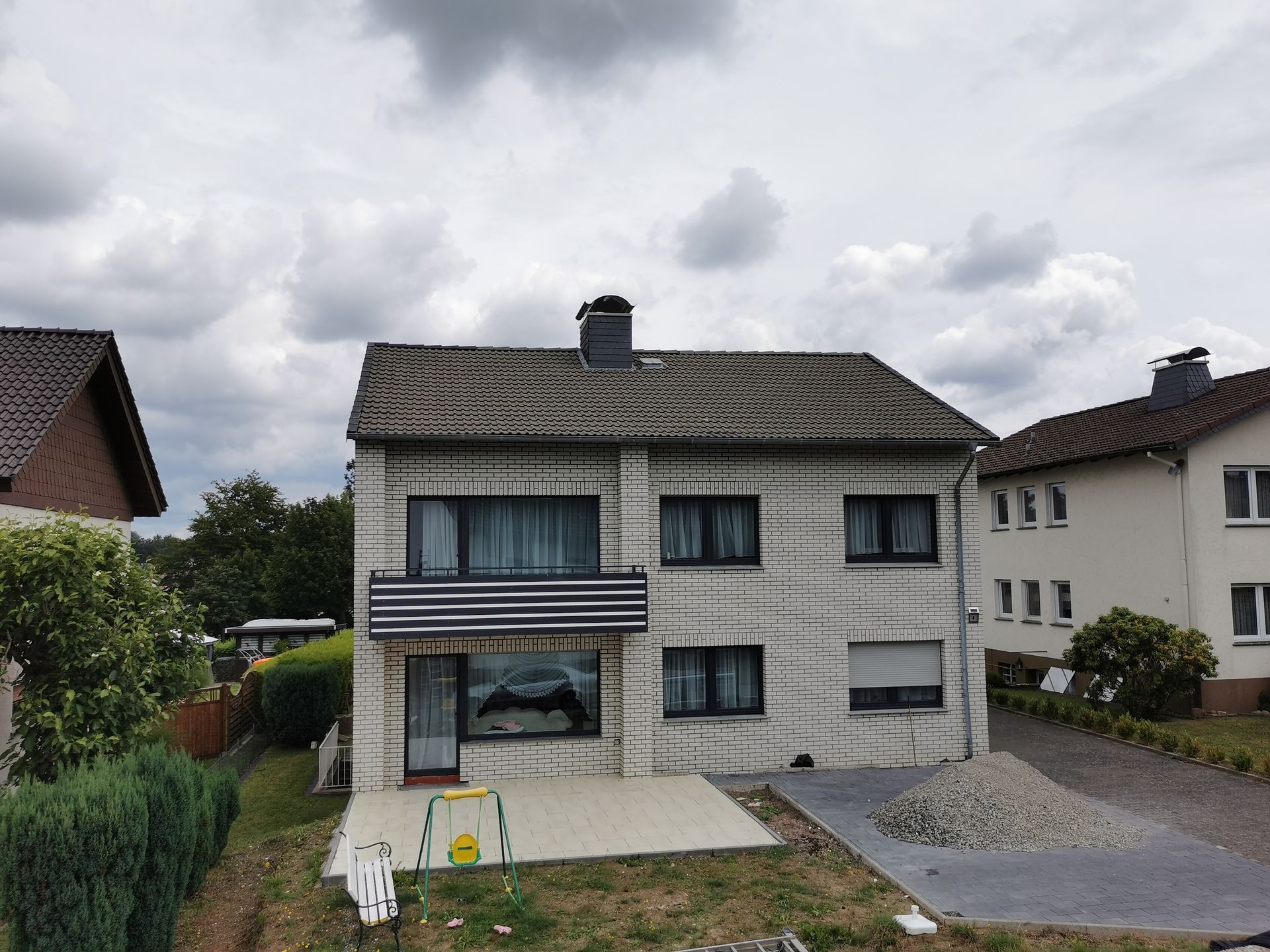 Ein großes weißes Backsteinhaus mit einem grauen Dach