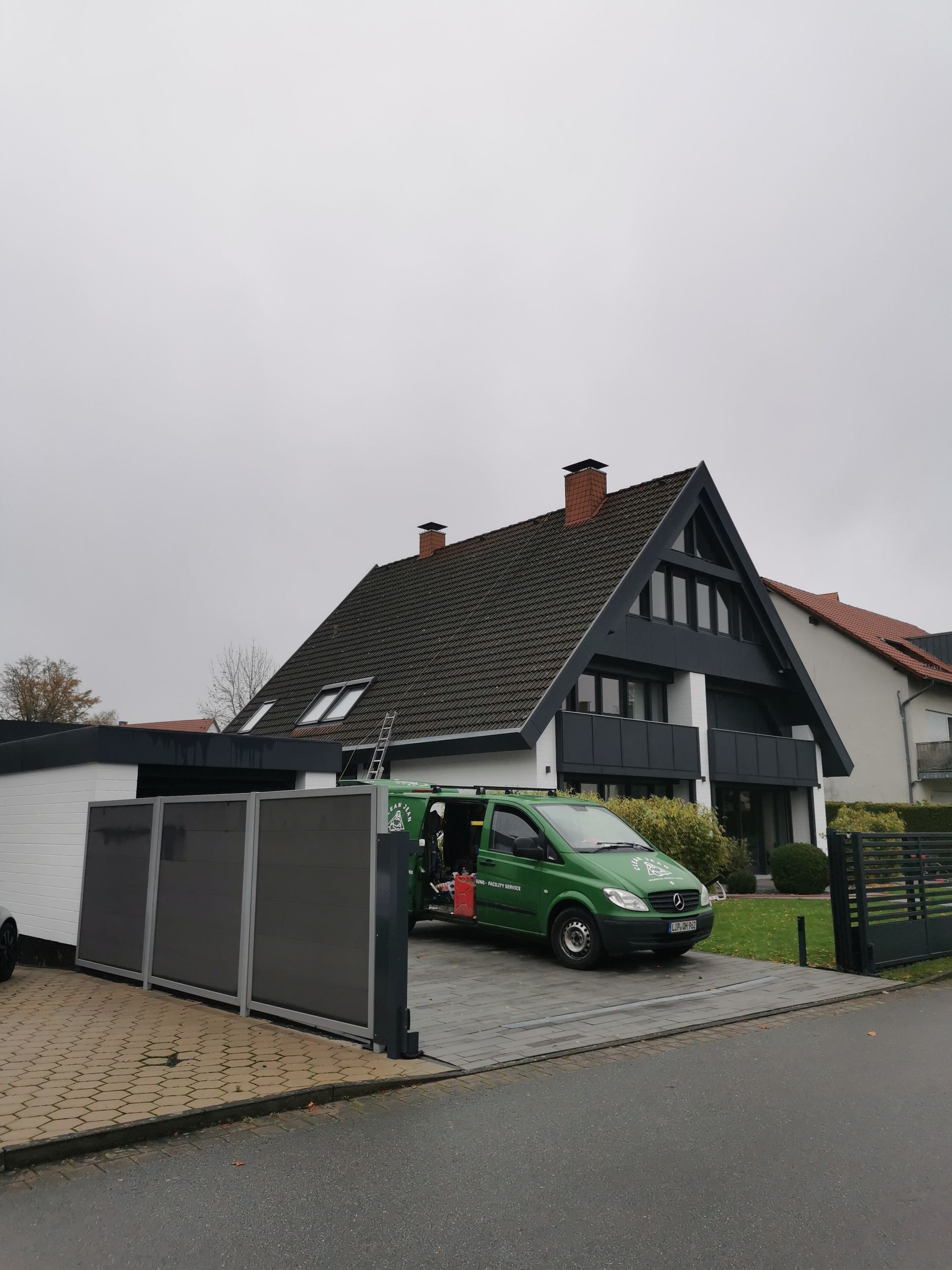 Ein grüner Lieferwagen steht vor einem Haus.