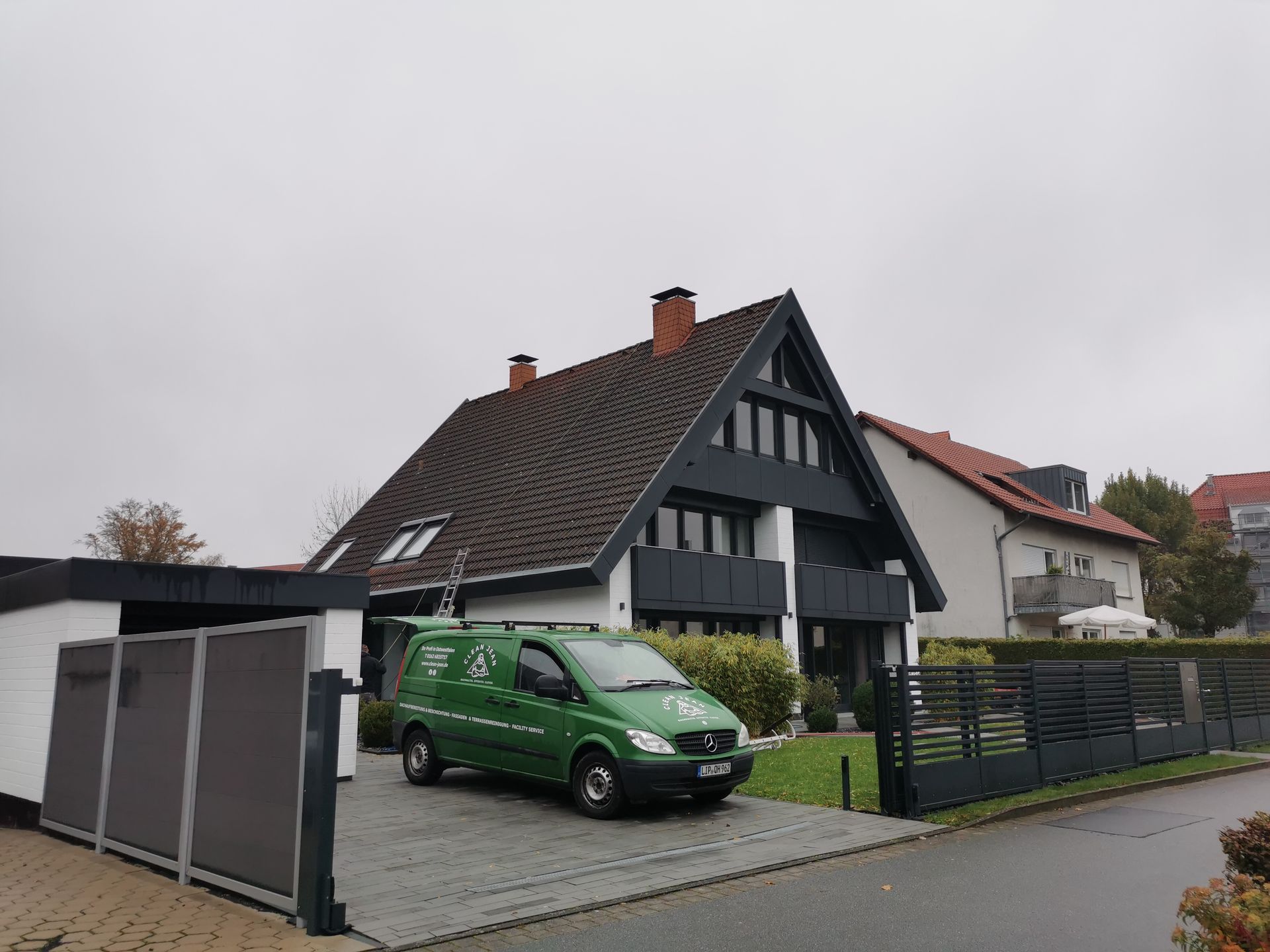 Ein grüner Lieferwagen steht vor einem Haus.