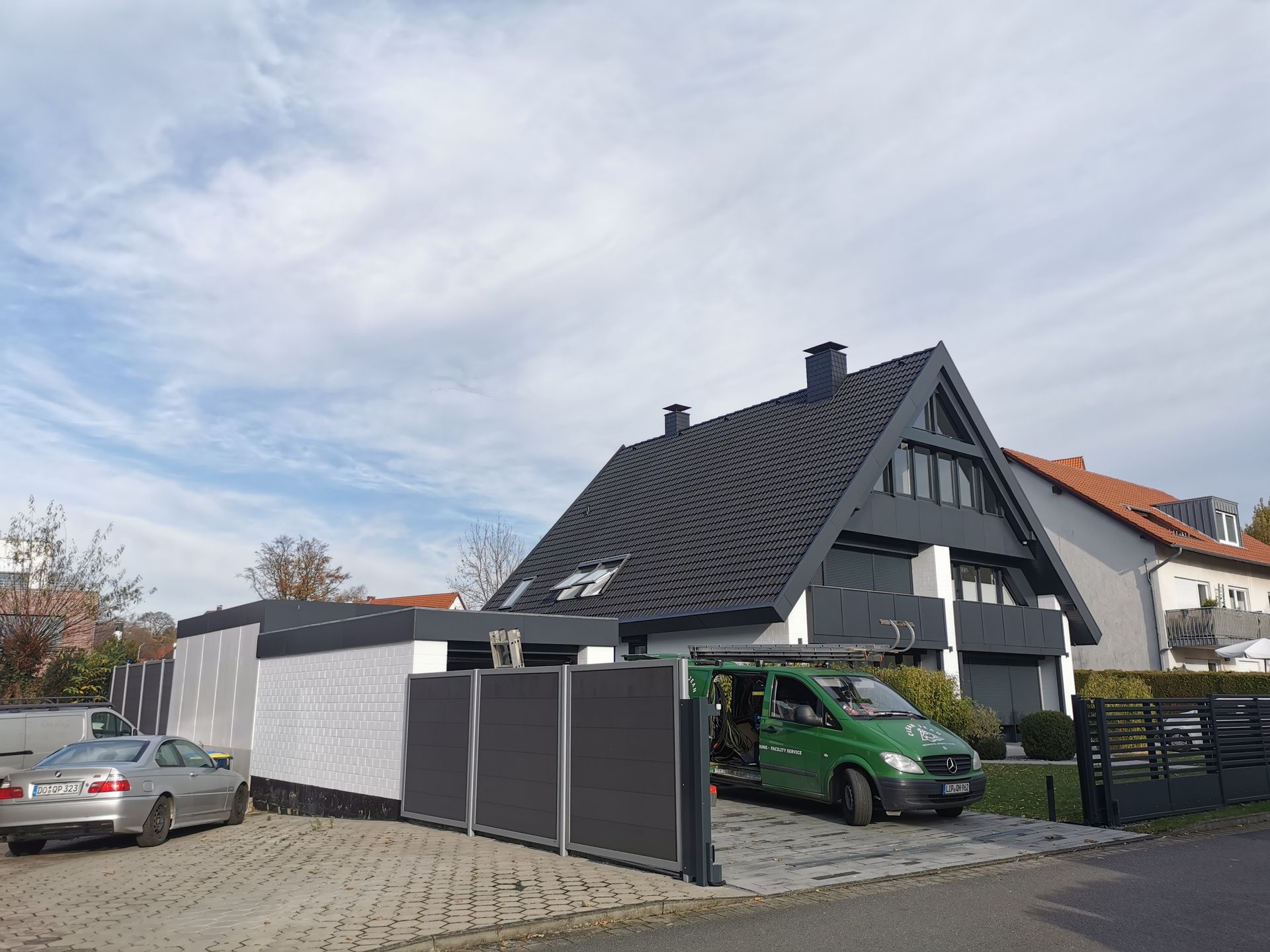 Ein grüner Lieferwagen steht vor einem Haus.