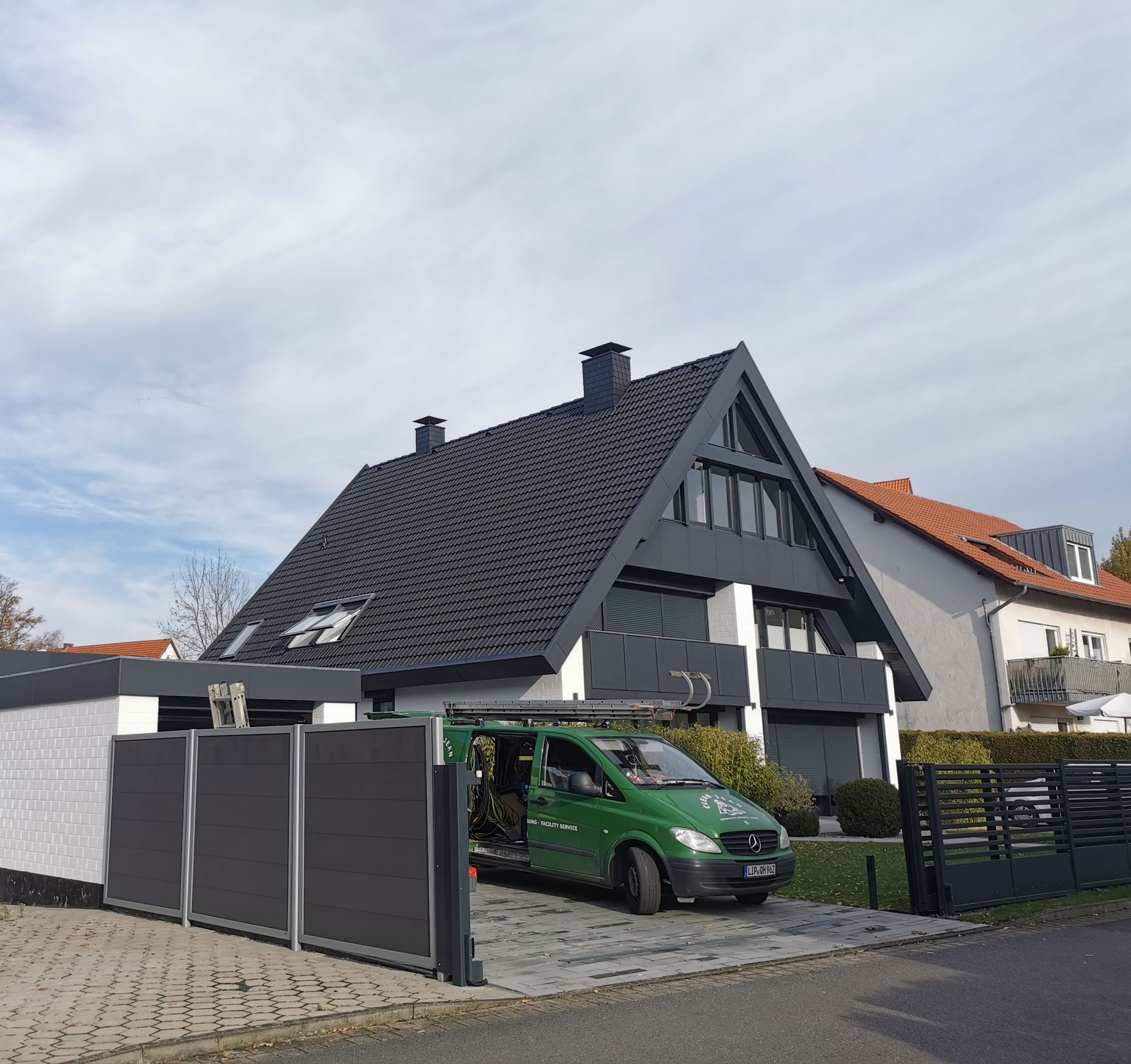 Ein grüner Lieferwagen steht vor einem Haus
