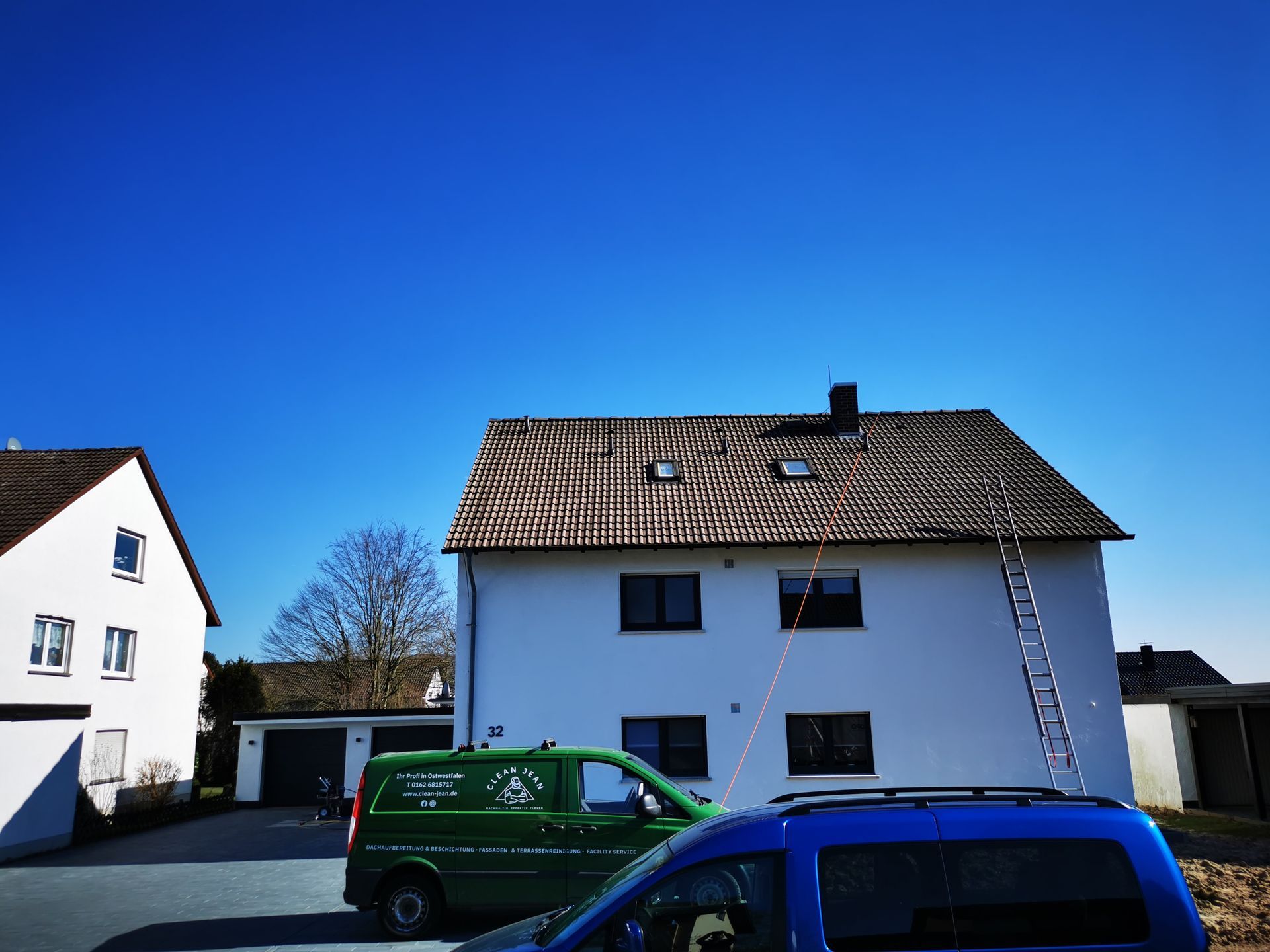 Ein grüner Van steht vor einem weißen Haus