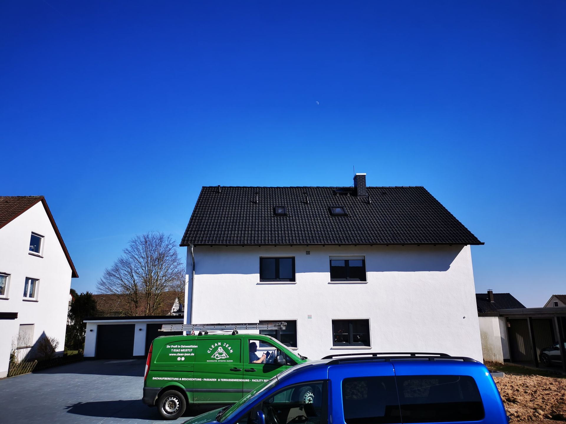 Ein grüner Van steht vor einem weißen Haus
