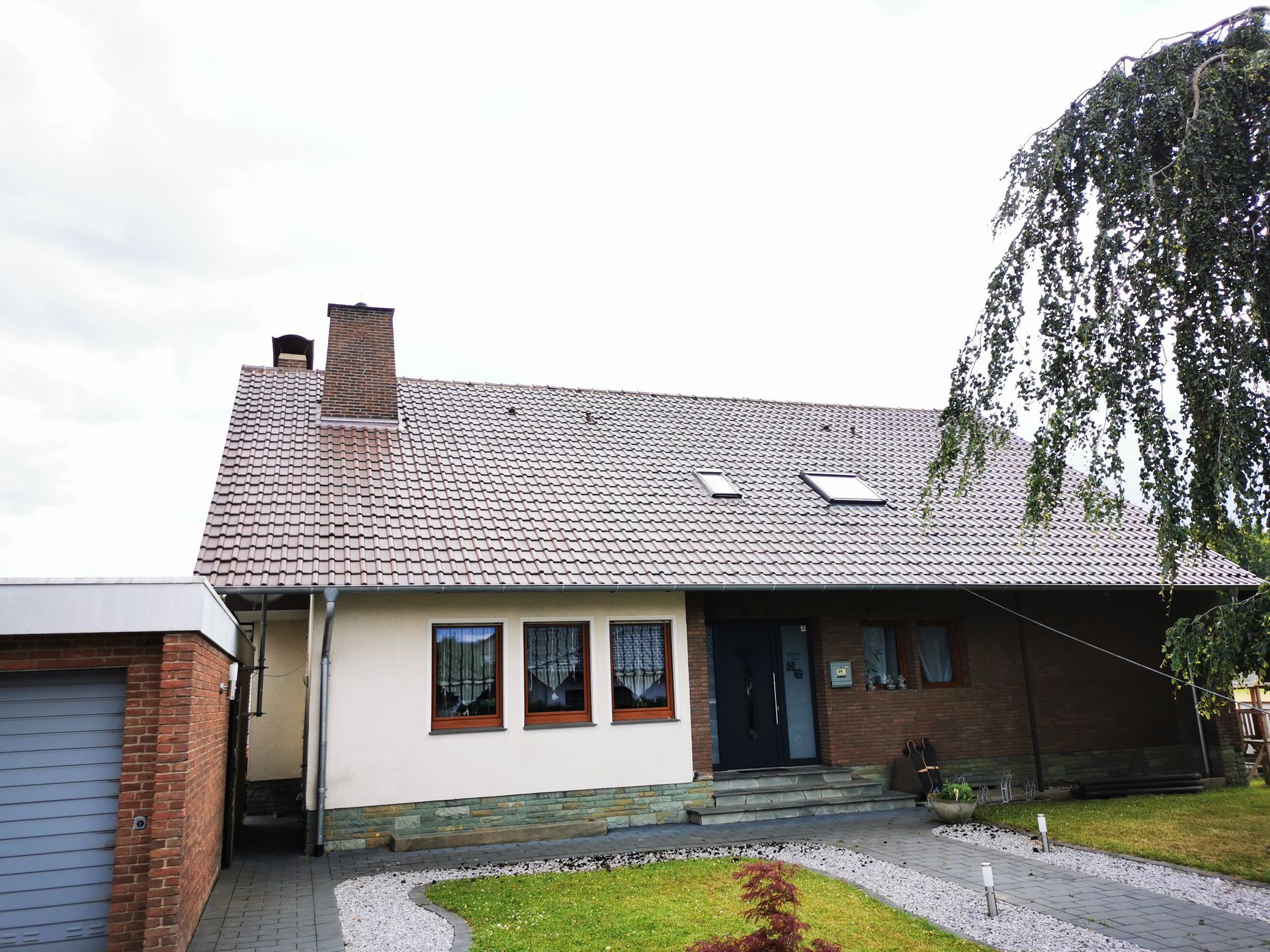 Ein Haus mit einem Dach, auf dem sich ein Oberlicht befindet